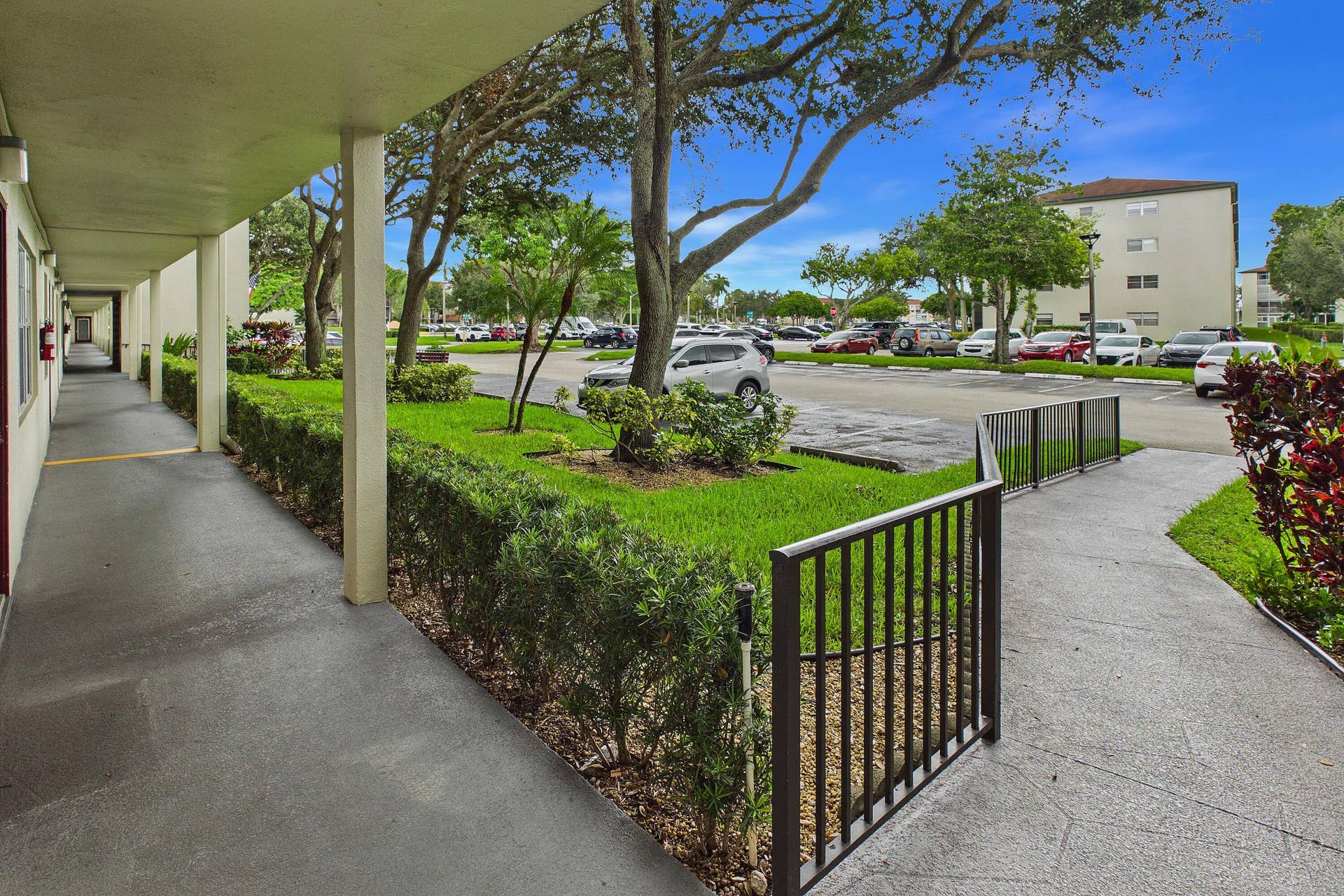 13155 SW 7TH Court, #103E, Pembroke Pines, FL 33027 Handicap accessible ramp right to the covered walkway with an open-air corridor.