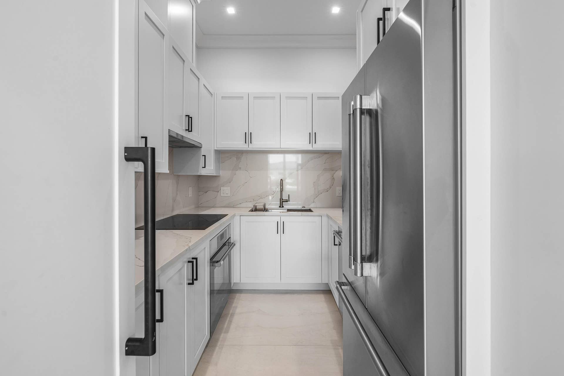 12898 S Shore Drive, Palm Beach Gardens, FL 33410 Your very own secondary butler's / prep kitchen featuring white cabinetry, electric range, stainless steel appliances, a built-in oven, and a marble-patterned backsplash