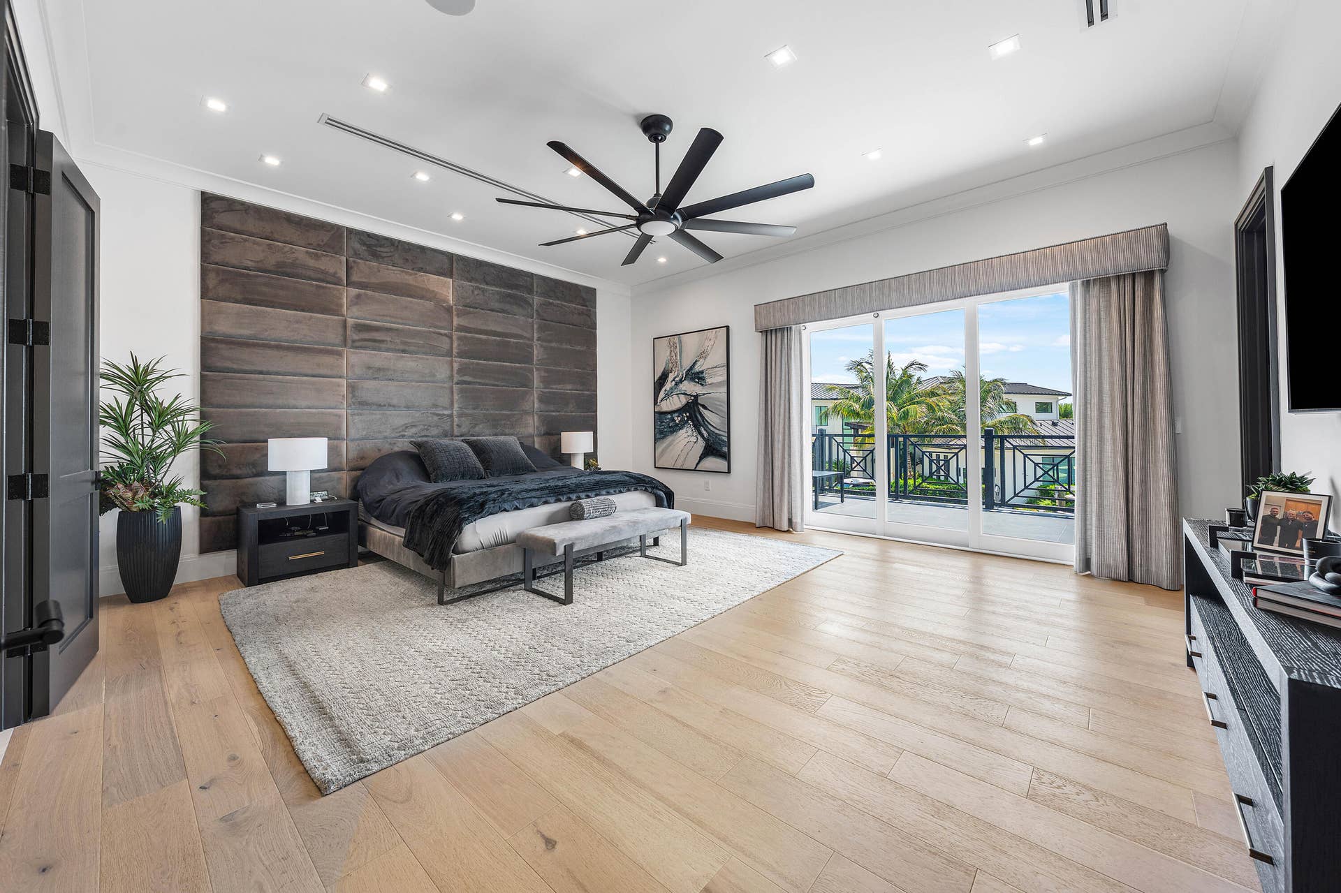 12898 S Shore Drive, Palm Beach Gardens, FL 33410 Wood-finish flooring, recessed lighting, ceiling fan, full-height paneled accent wall, and sliding glass doors to the Intracoastal Waterway