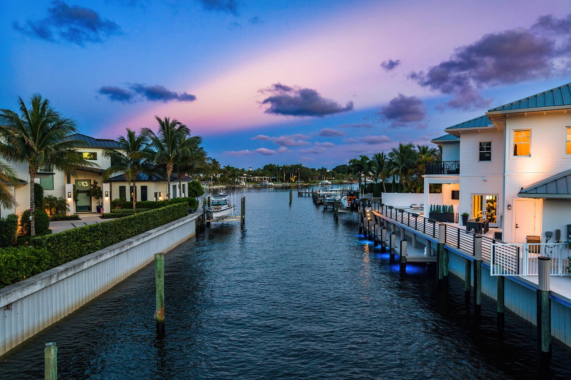 12898 S Shore Drive, Palm Beach Gardens, FL 33410 Waterfront property featuring multiple boat docks, private patios, balconies, and manicured landscaping