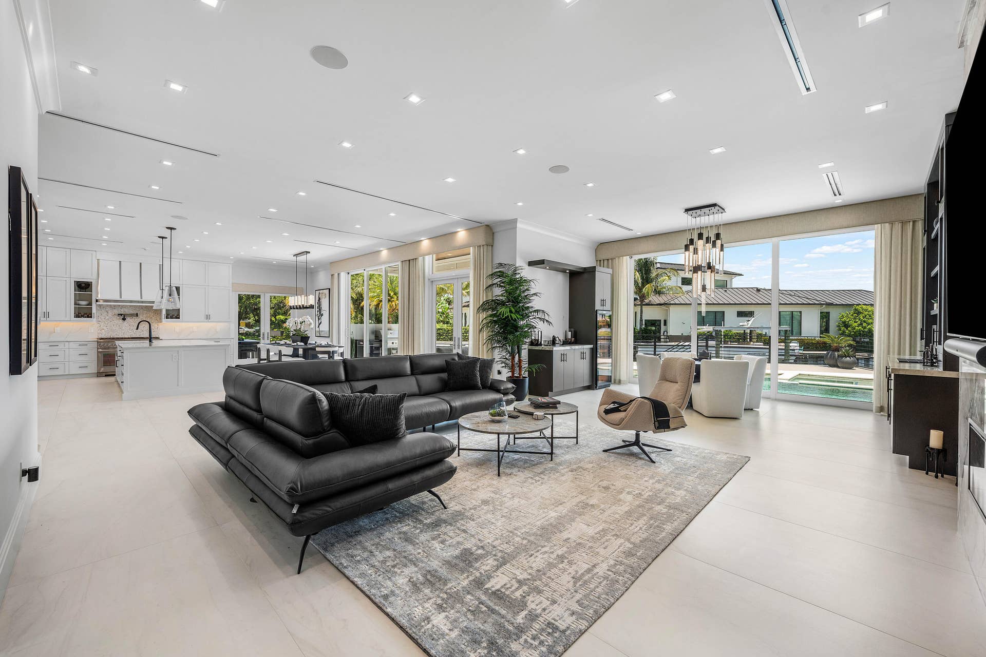 12898 S Shore Drive, Palm Beach Gardens, FL 33410 Open-concept living area featuring light-toned flooring, recessed lighting, linear air vents and expansive glass doors