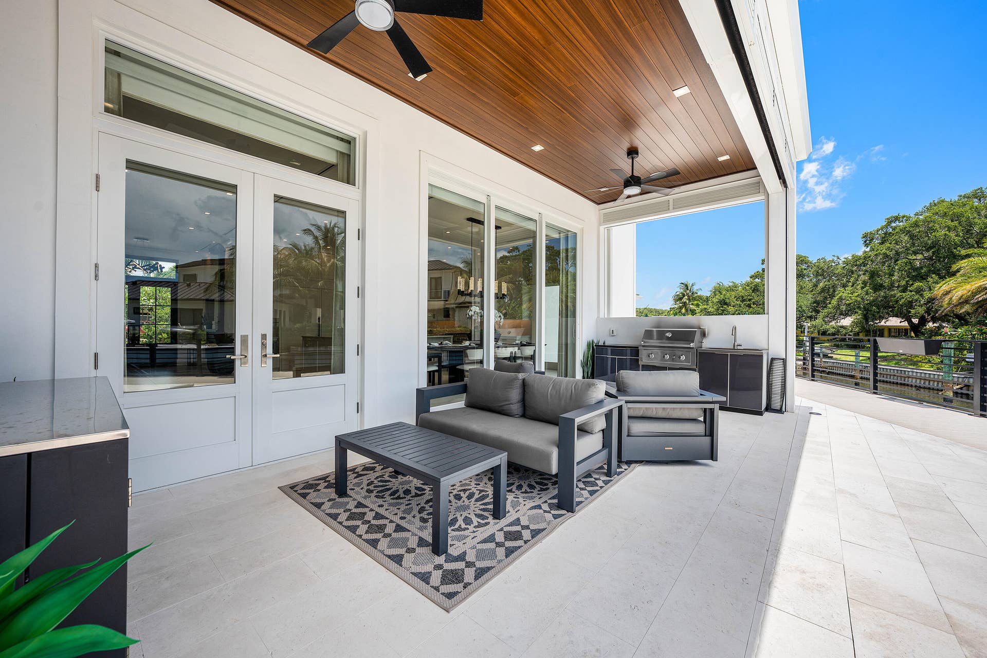 12898 S Shore Drive, Palm Beach Gardens, FL 33410 Covered outdoor living area with wood-panel ceiling, recessed lighting, and ceiling fans
