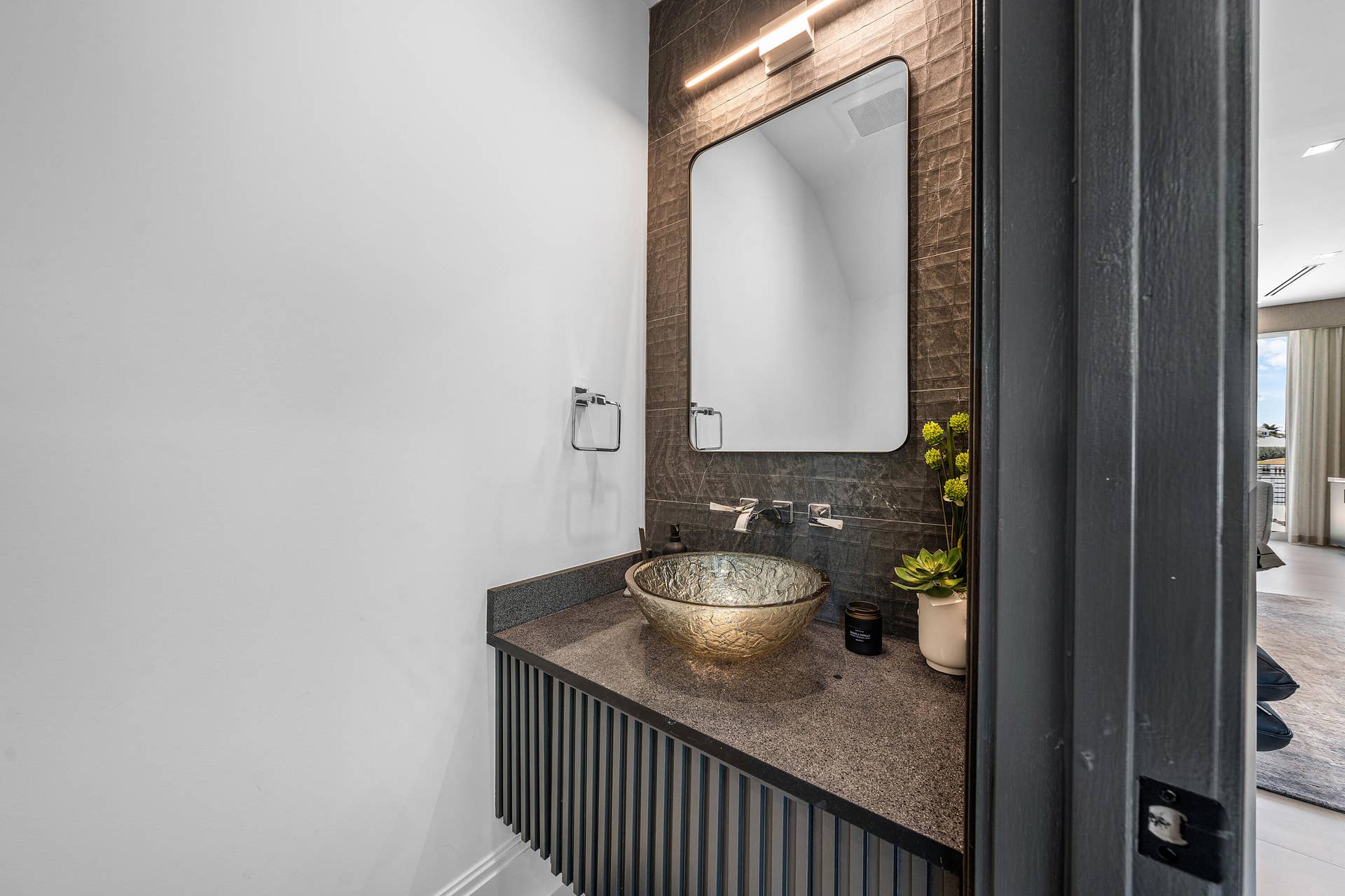 12898 S Shore Drive, Palm Beach Gardens, FL 33410 Floating vanity with a fluted wood-finish base, stone countertop, and glass vessel sink