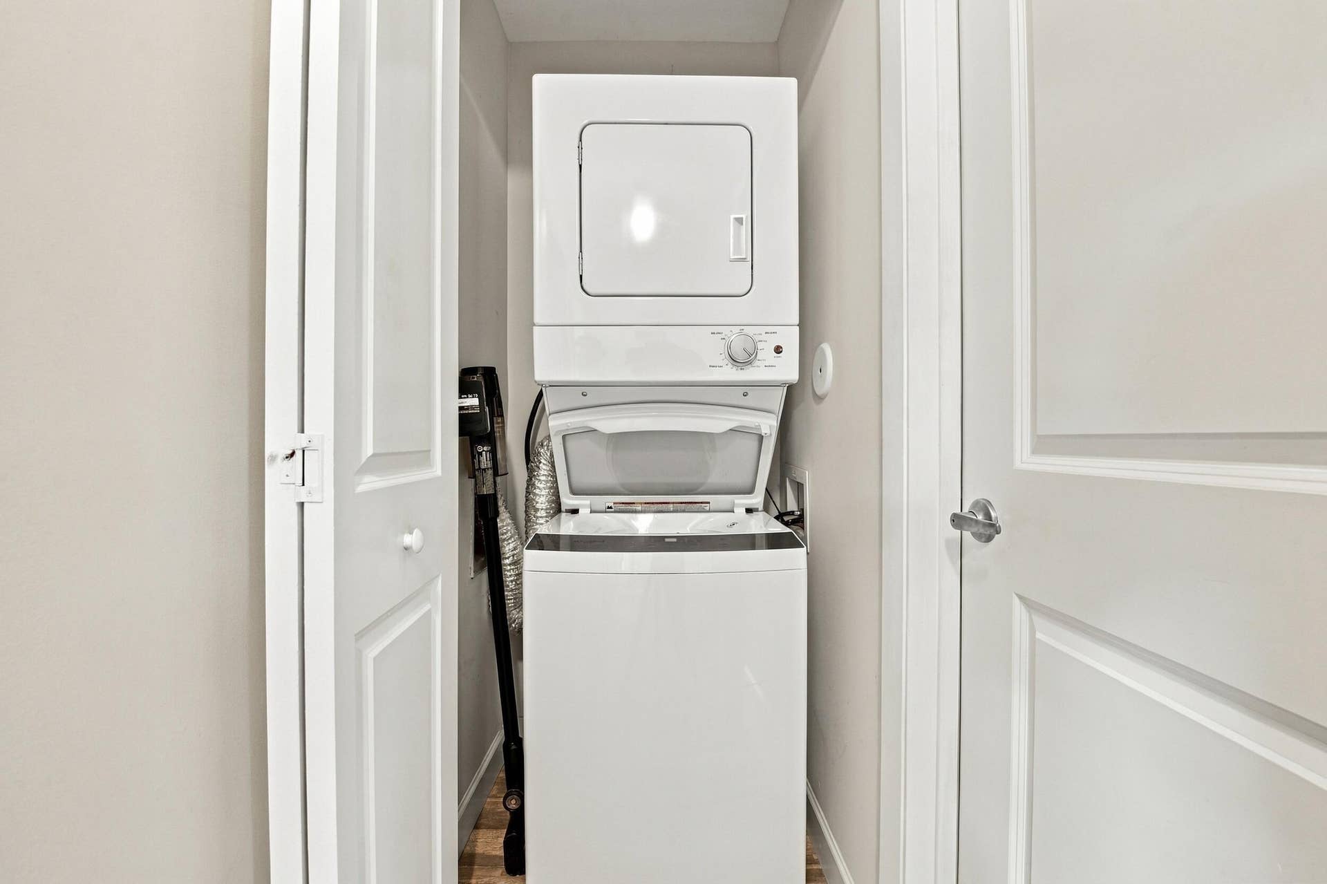 White stackable washer and dryer within a dedicated utility closet