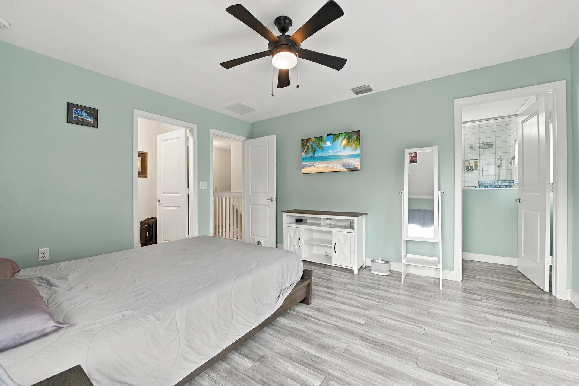 Wood-finish flooring throughout, ceiling fan with integrated lighting, and white paneled doors