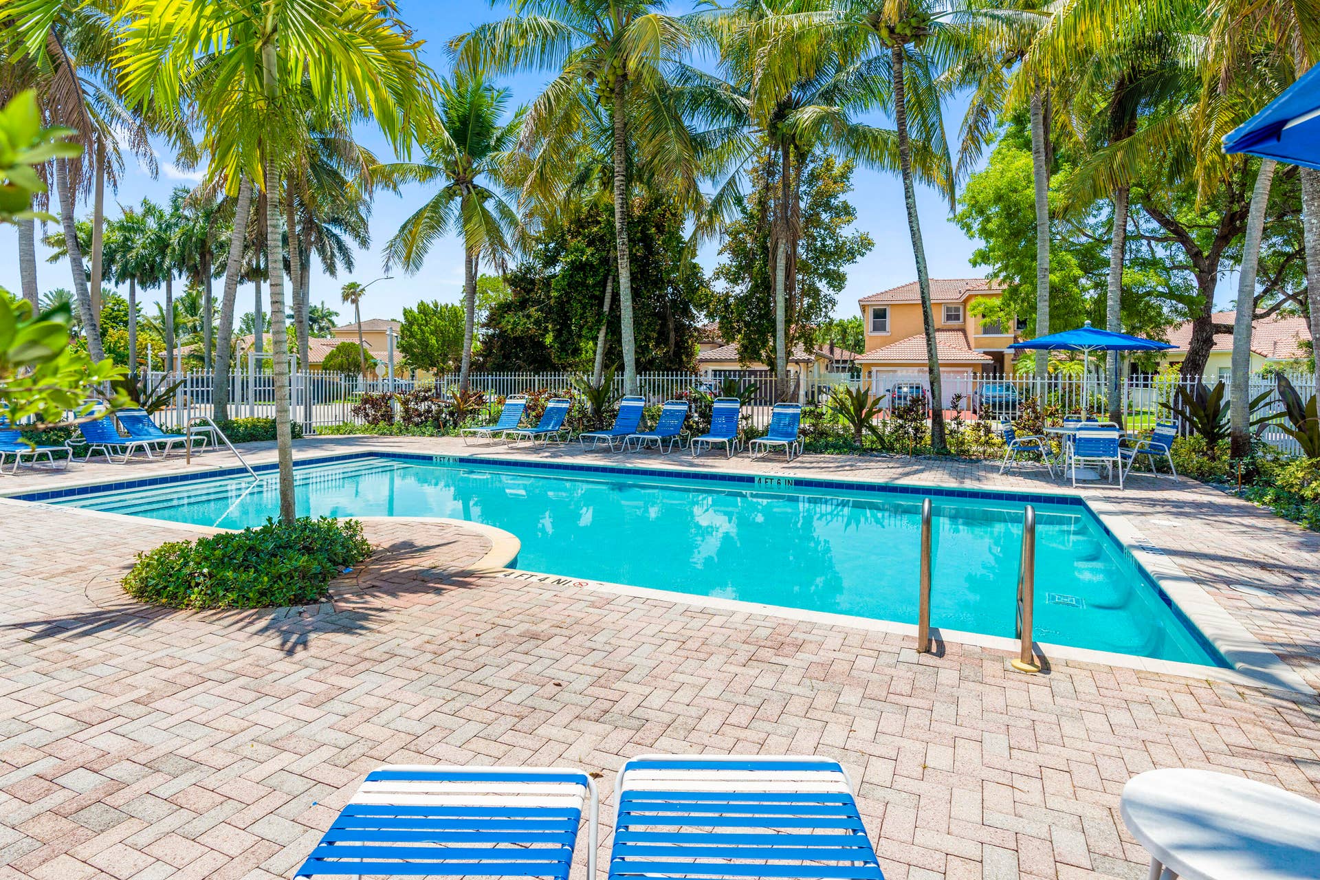 Mariposa Isles community pool area with surrounding lounge space and playground.