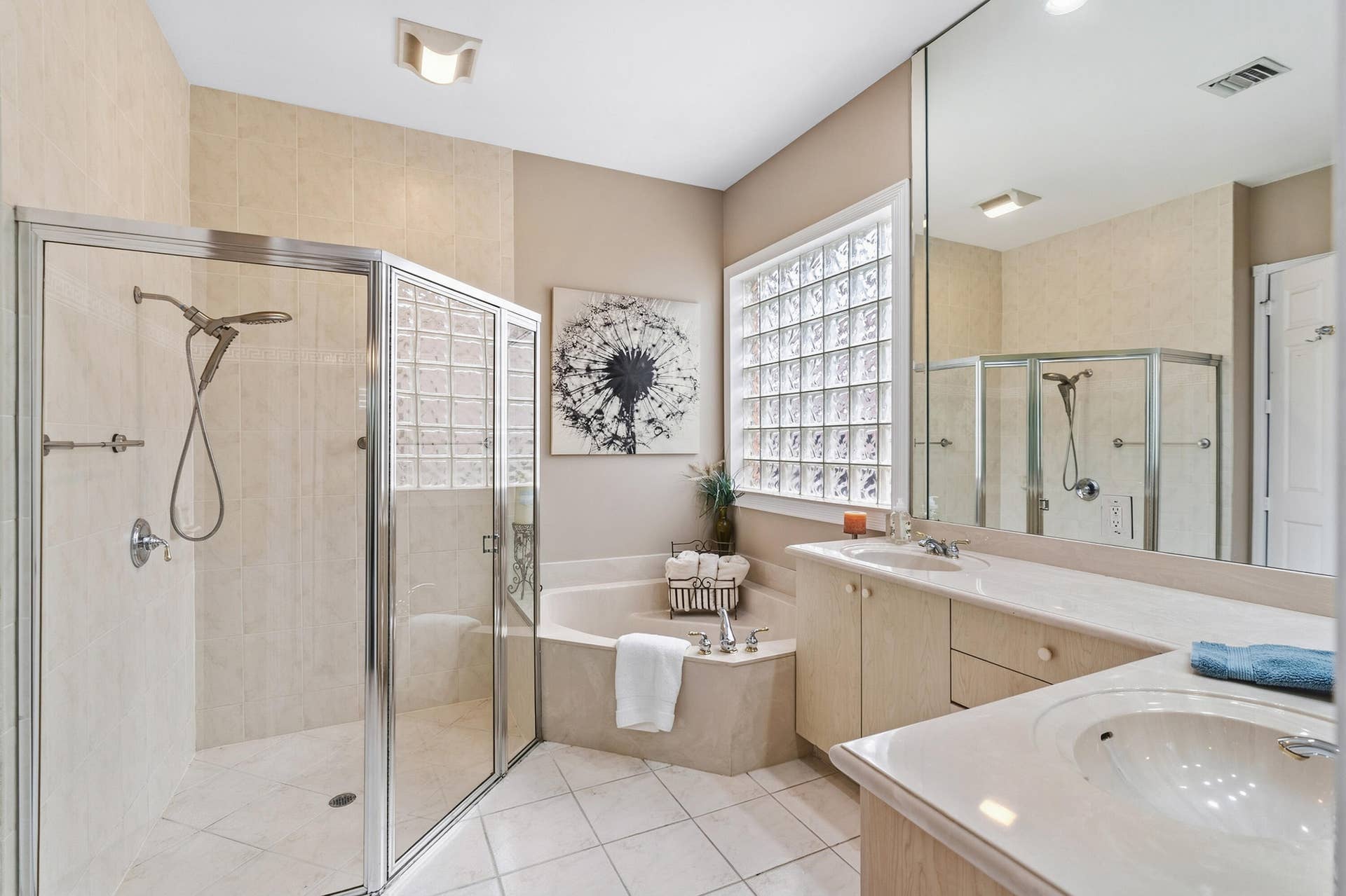 Primary bath features dual vanities, a separate shower and soaking tub.