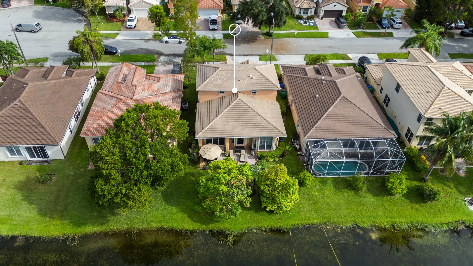 Aerial view from the lake showcasing the home, backyard and direct waterfront setting within the neighborhood.