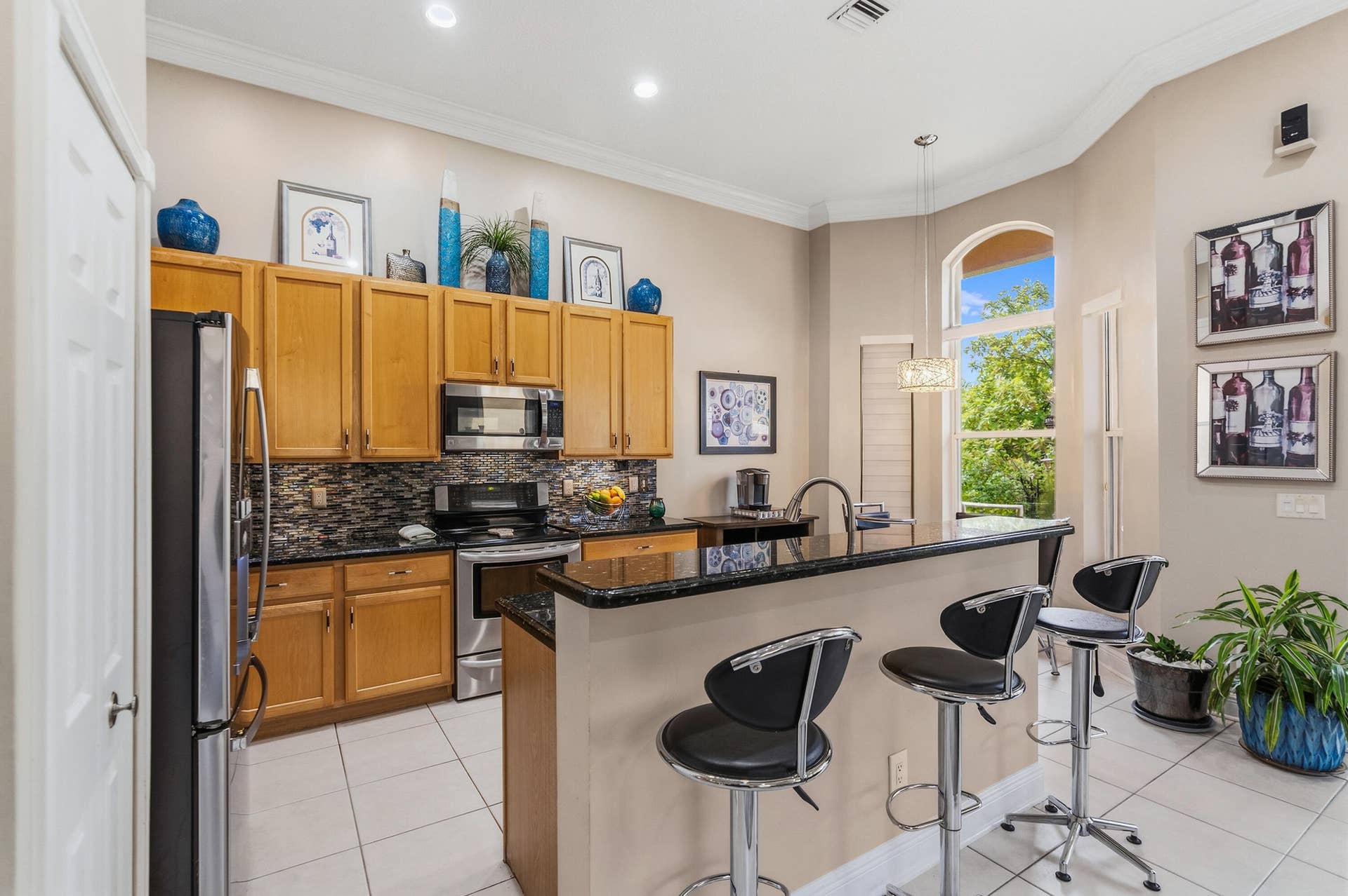 Kitchen with granite counters, stainless steel appliances, breakfast-bar seating, and an adjacent dining area.