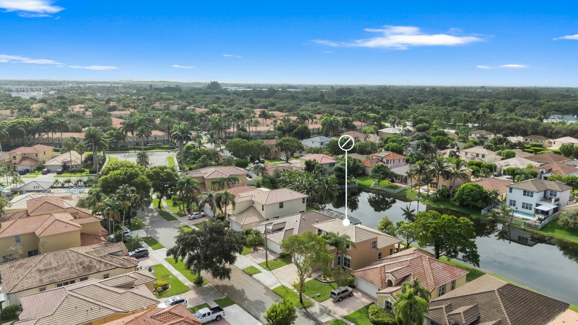 Wide aerial perspective highlighting the homes location within the established Monarch Lakes community and its surrounding waterways.