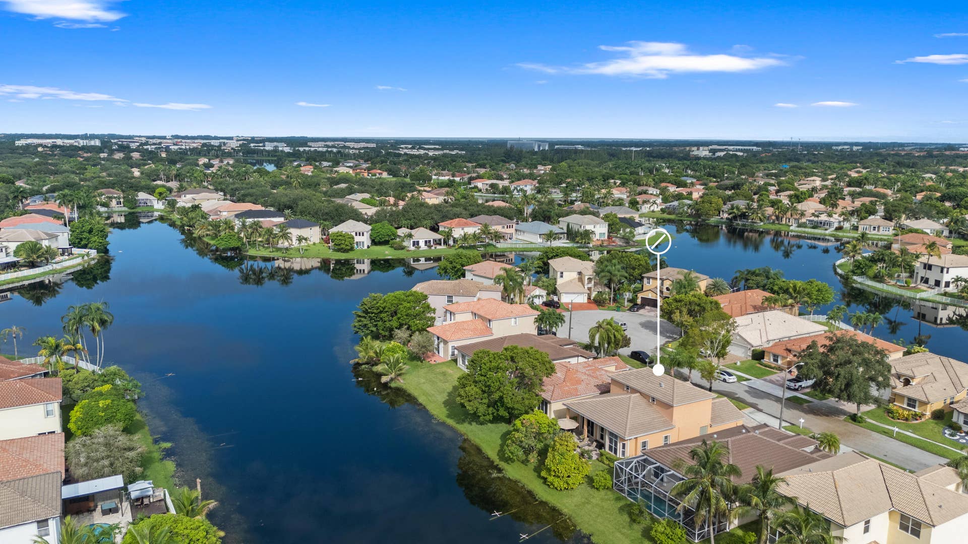 Expansive aerial perspective showcasing the homes waterfront location and the scenic lake-filled community.