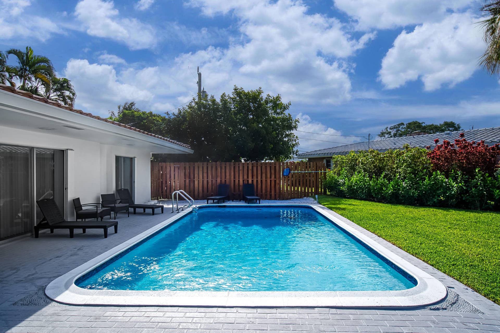 1250 SE 10TH Street, Deerfield Beach, Deerfield Beach, FL 33441 Rectangular swimming pool with integrated steps and a surrounding paver patio