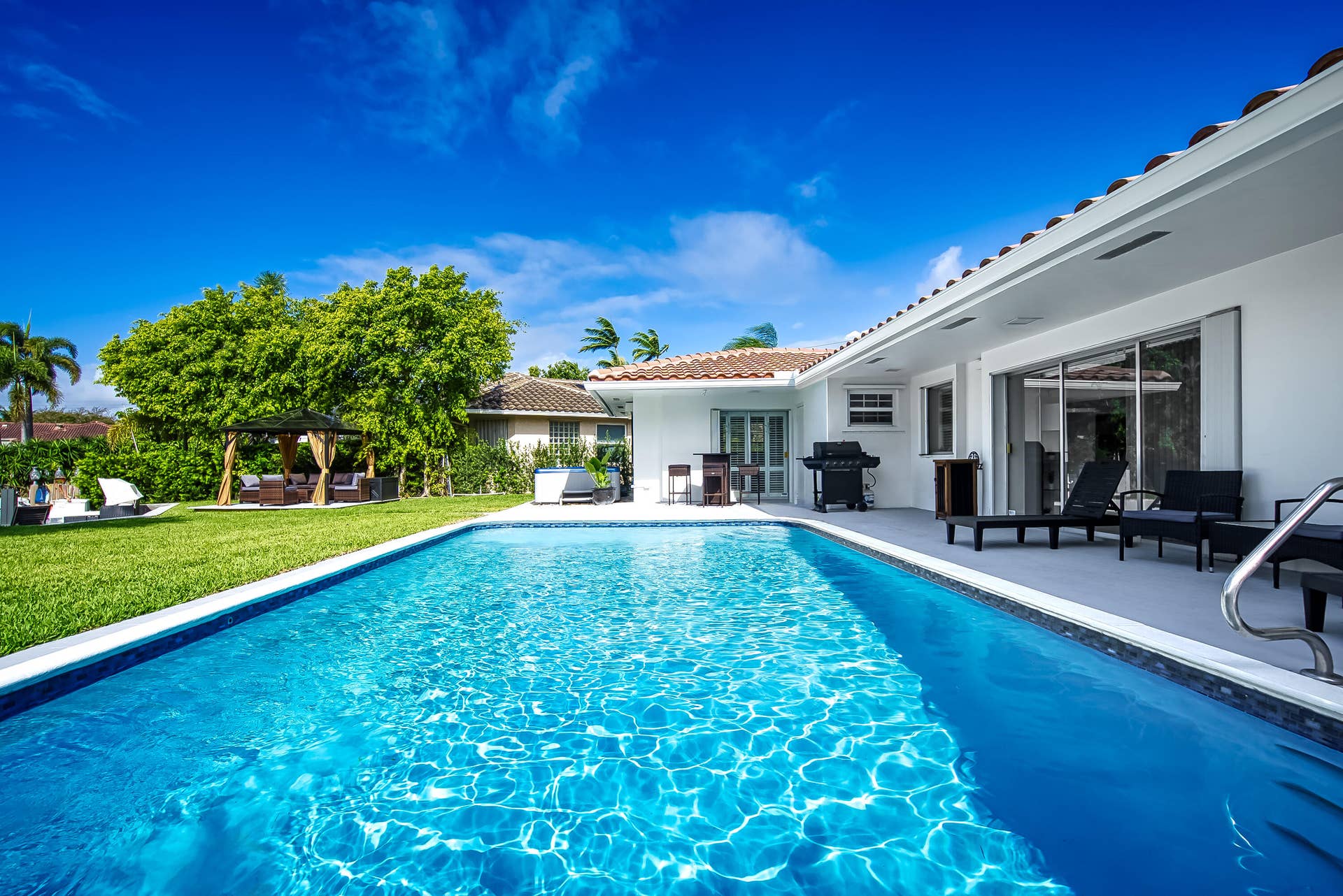 1250 SE 10TH Street, Deerfield Beach, Deerfield Beach, FL 33441 In-ground swimming pool with a tiled edge, surrounded by a concrete patio