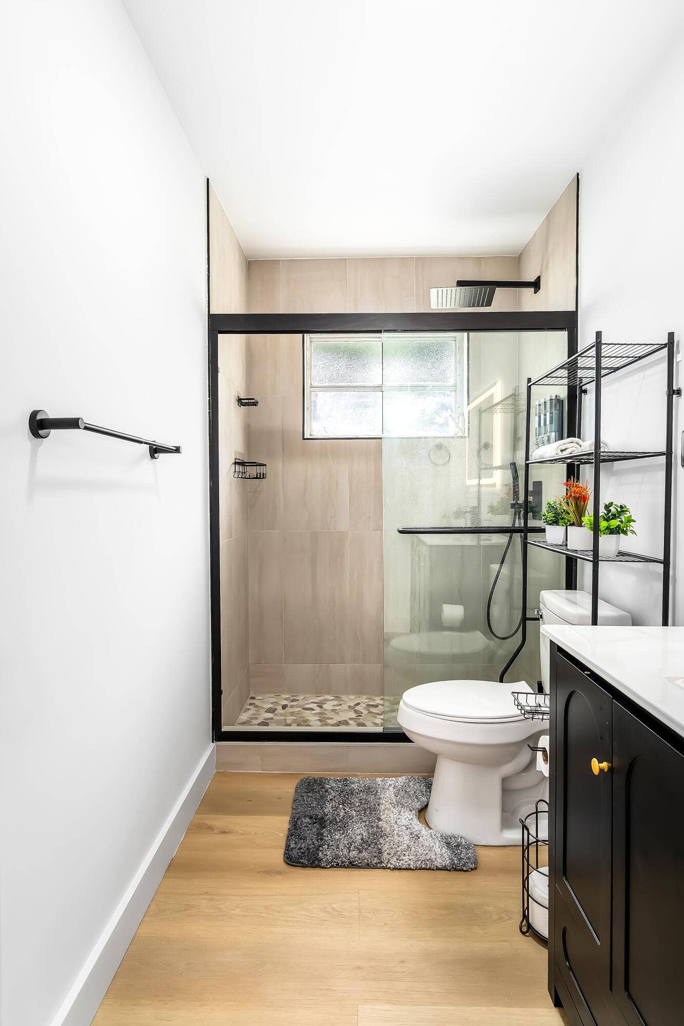 1250 SE 10TH Street, Deerfield Beach, Deerfield Beach, FL 33441 Contemporary bathroom featuring a glass-enclosed shower with tiled walls and a pebble-finish floor