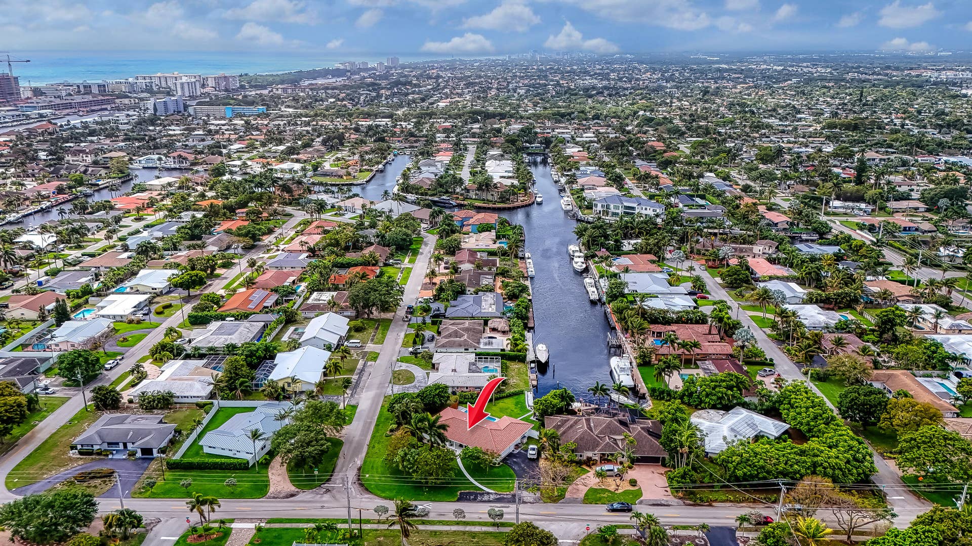 1250 SE 10TH Street, Deerfield Beach, Deerfield Beach, FL 33441 Aerial neighborhood overview with extensive canal system, residential properties, manicured landscaping, and distant ocean presence