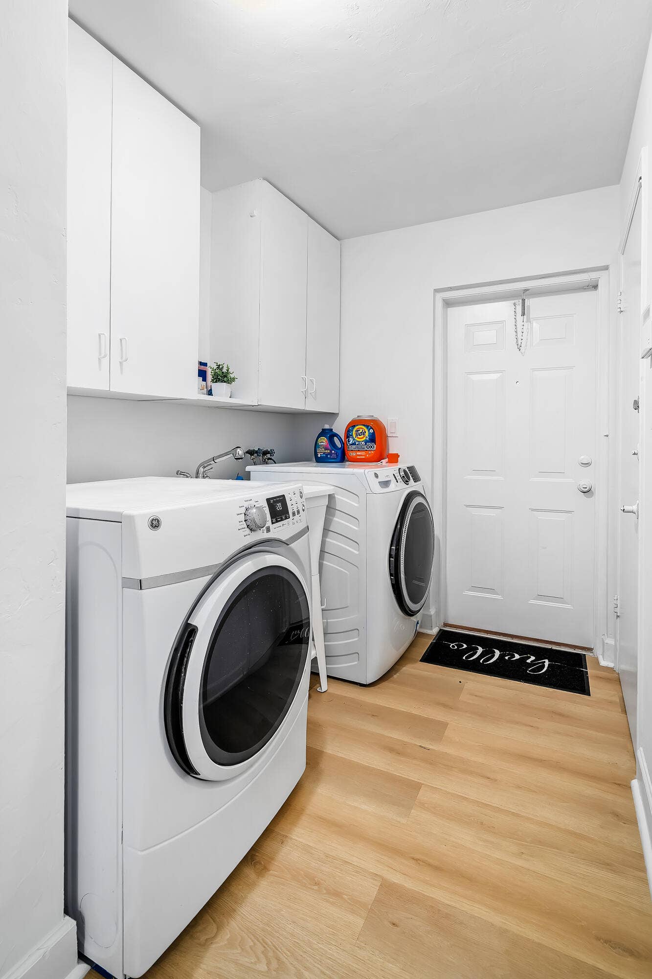 1250 SE 10TH Street, Deerfield Beach, Deerfield Beach, FL 33441 Dedicated laundry area featuring a front-load washer and dryer, light wood-finish flooring, and white cabinetry