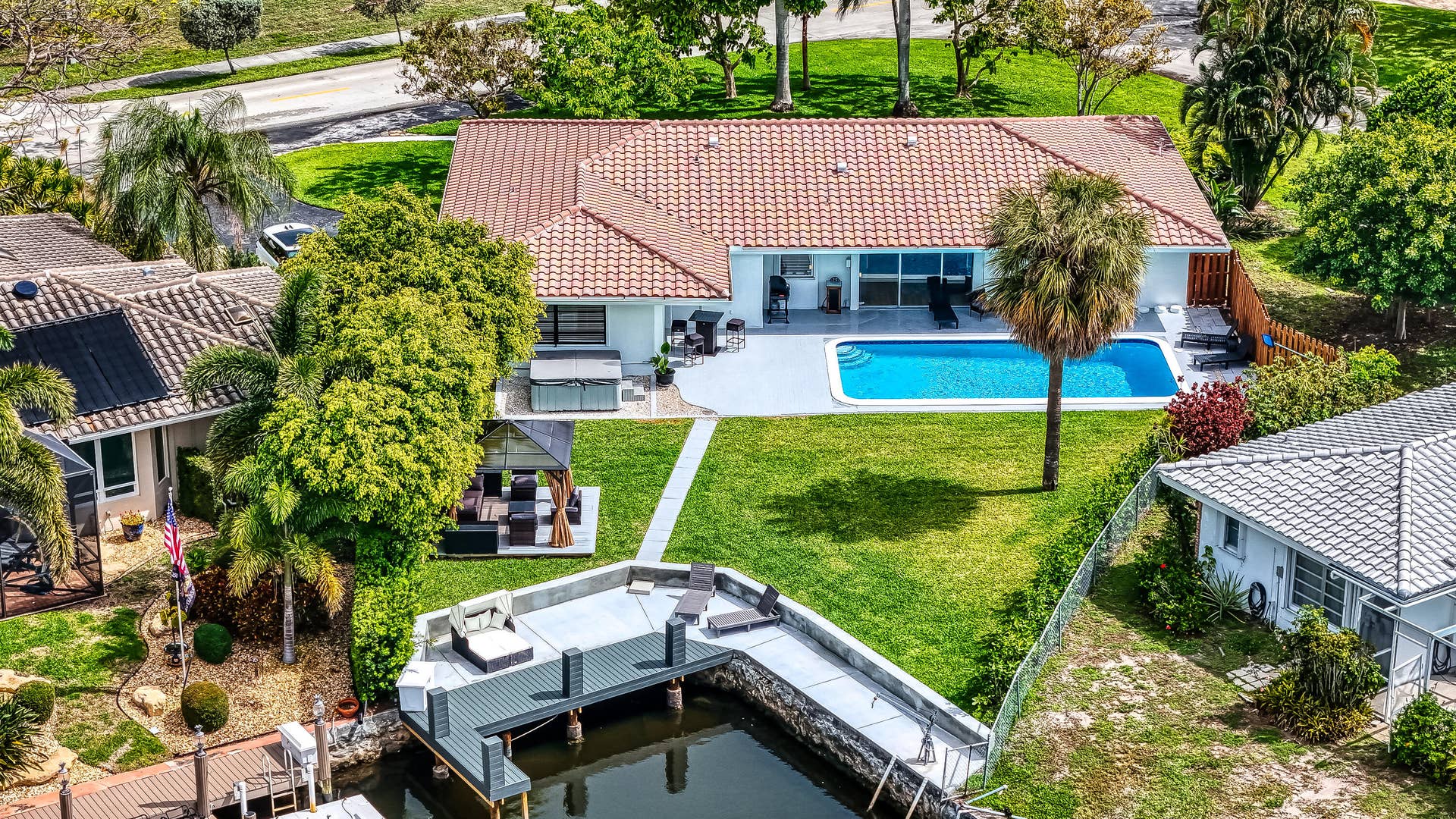 1250 SE 10TH Street, Deerfield Beach, Deerfield Beach, FL 33441 Waterfront property featuring a private dock, inground swimming pool, spacious patio, lush lawn, and mature landscaping