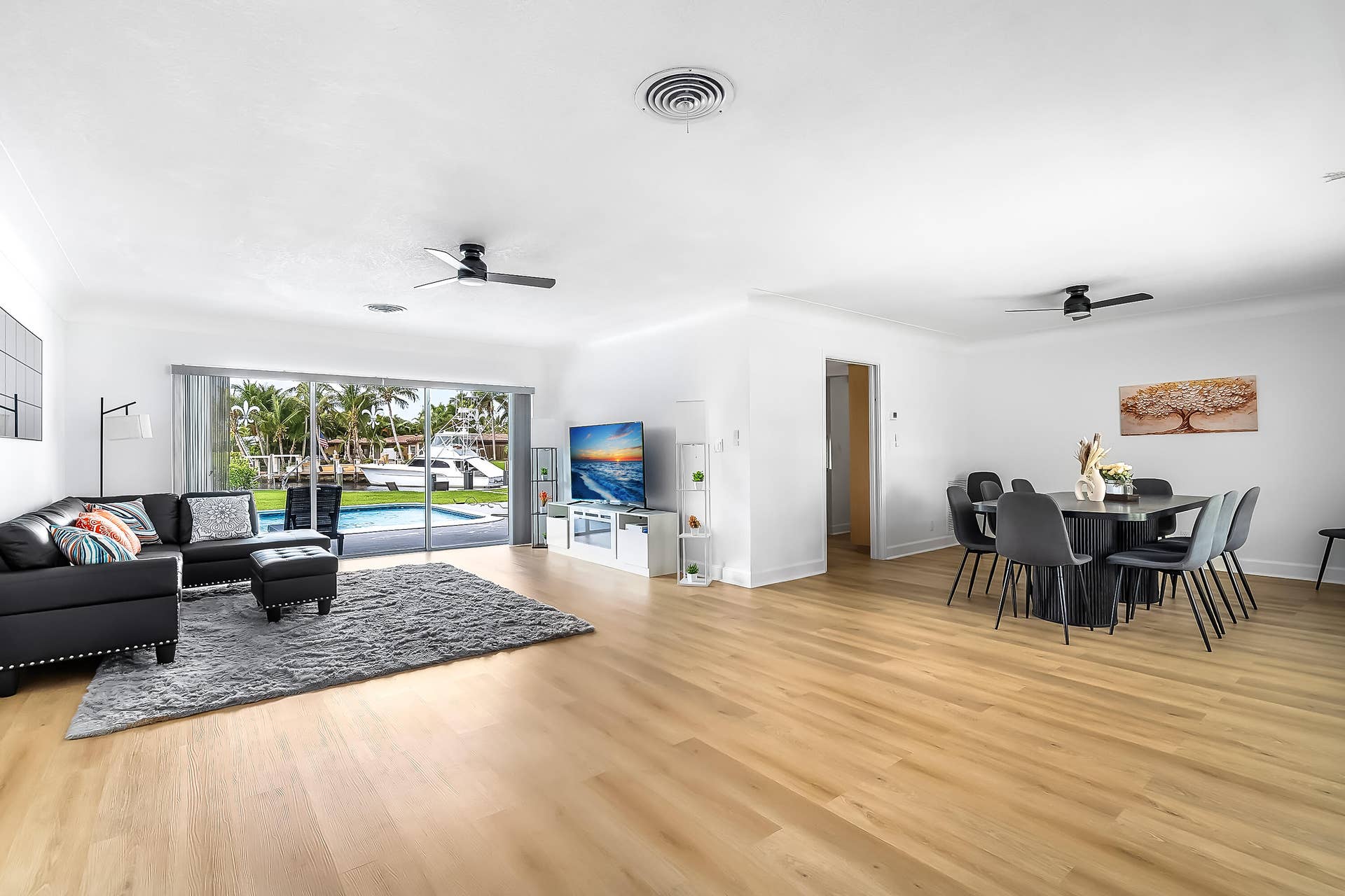 1250 SE 10TH Street, Deerfield Beach, Deerfield Beach, FL 33441 Expansive living area with light wood-finish flooring extending into the dining space