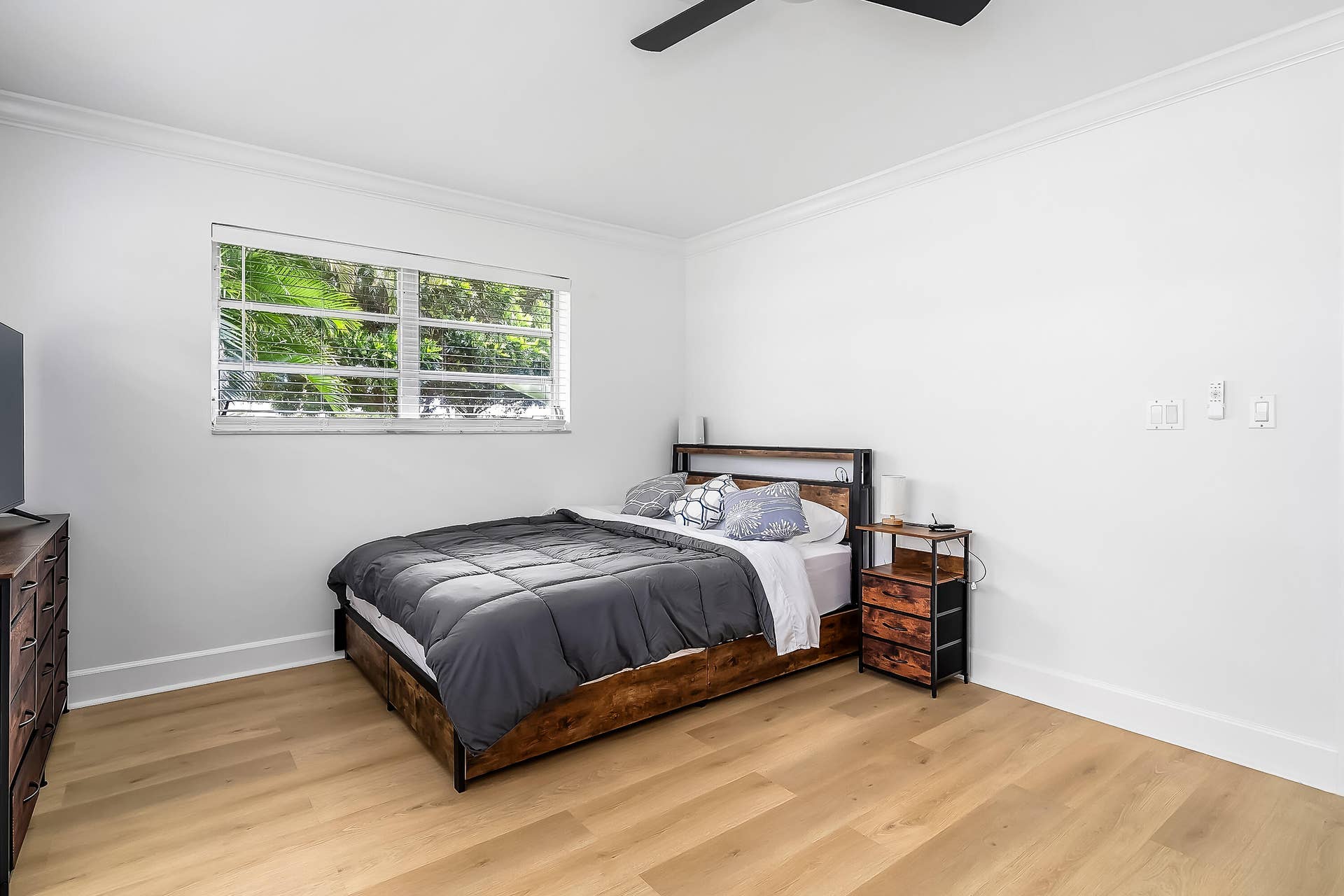 1250 SE 10TH Street, Deerfield Beach, Deerfield Beach, FL 33441 Spacious room featuring light wood-finish flooring, a window with horizontal blinds, crisp white walls, and crown molding