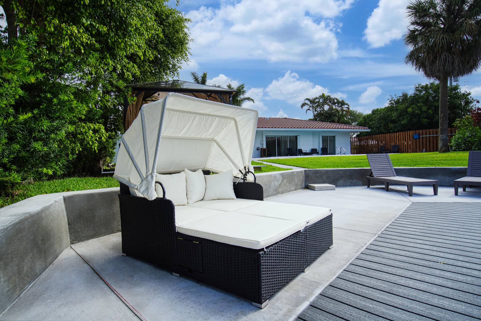 1250 SE 10TH Street, Deerfield Beach, Deerfield Beach, FL 33441 Outdoor entertaining area featuring concrete paving, composite decking, and a low concrete retaining wall