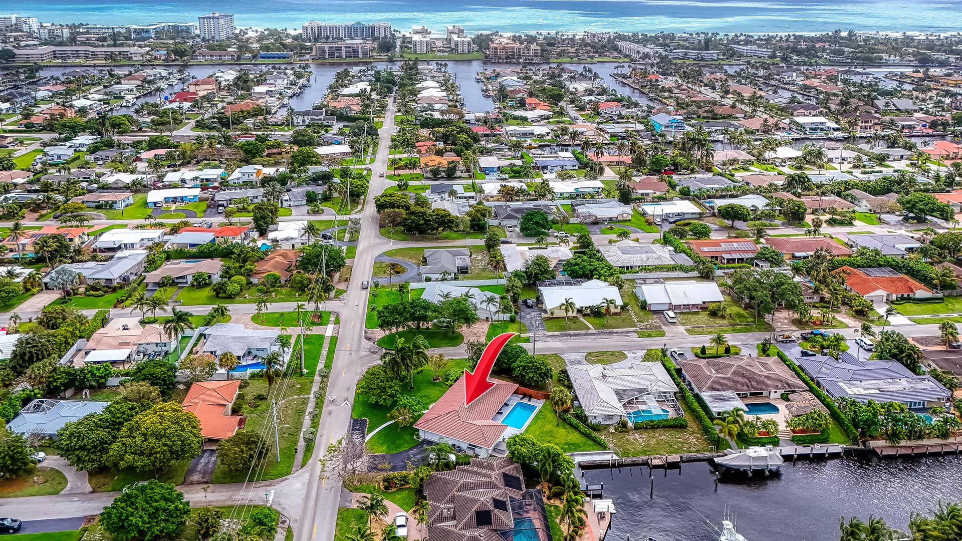 1250 SE 10TH Street, Deerfield Beach, Deerfield Beach, FL 33441 Waterfront property featuring a private boat dock, a rectangular swimming pool, and a red tile roof