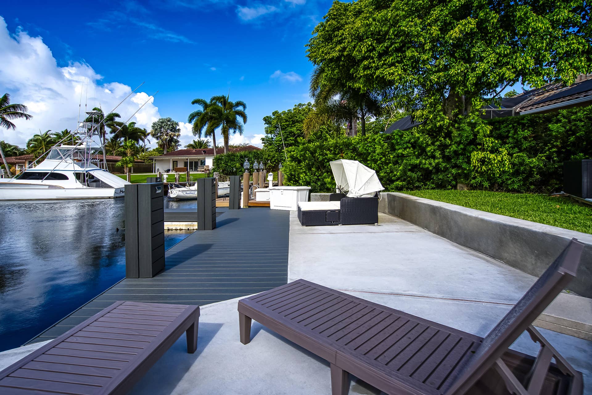 1250 SE 10TH Street, Deerfield Beach, Deerfield Beach, FL 33441 Waterfront property featuring a private boat dock, concrete patio, and lush green landscaping