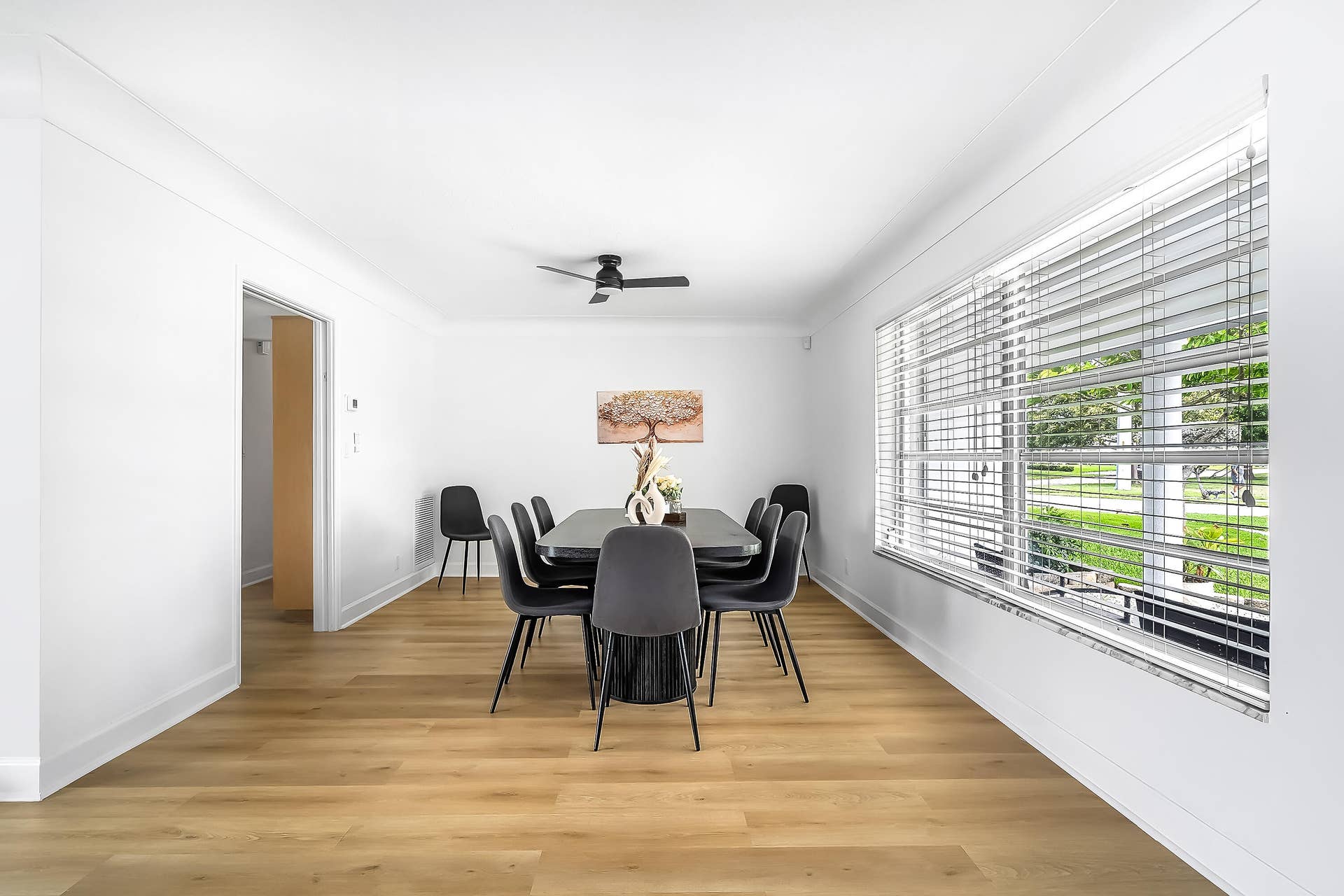 1250 SE 10TH Street, Deerfield Beach, Deerfield Beach, FL 33441 Bright interior space featuring wood-finish flooring, white walls, and a large window with horizontal blinds