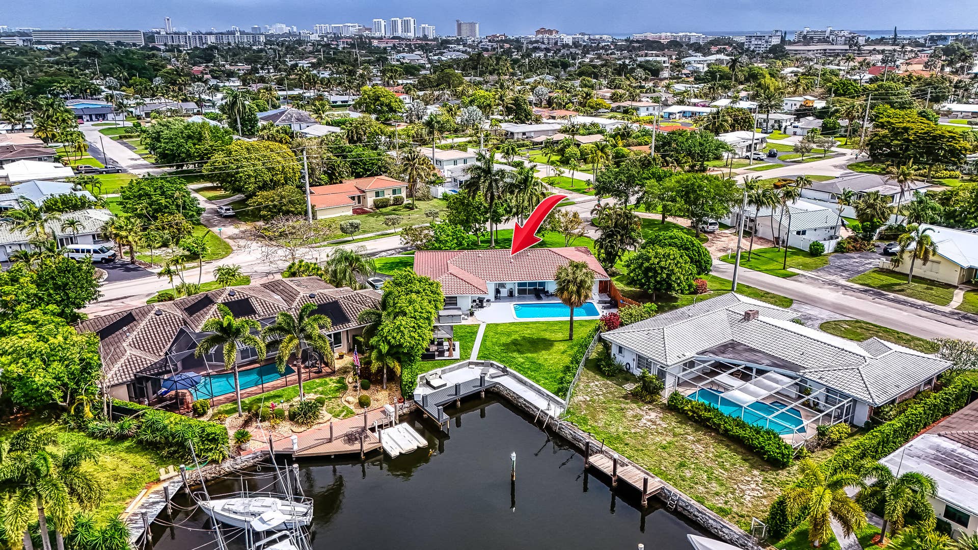 1250 SE 10TH Street, Deerfield Beach, Deerfield Beach, FL 33441 Waterfront property featuring a private dock, canal access, a manicured lawn, and an in-ground swimming pool