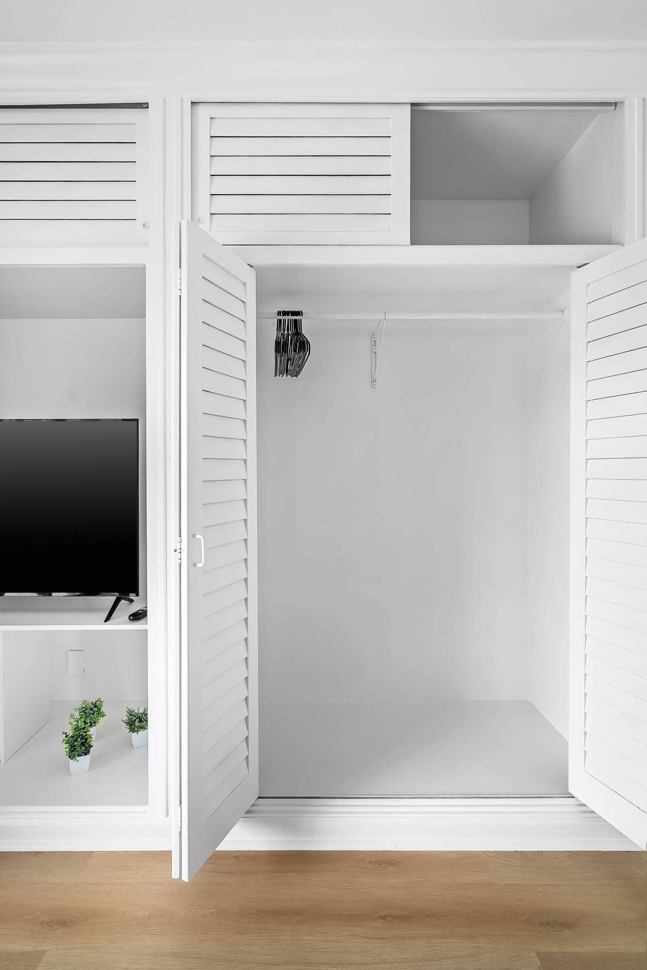 1250 SE 10TH Street, Deerfield Beach, Deerfield Beach, FL 33441 Built-in white cabinetry with louvered doors, a clothes hanging rod, and integrated shelving