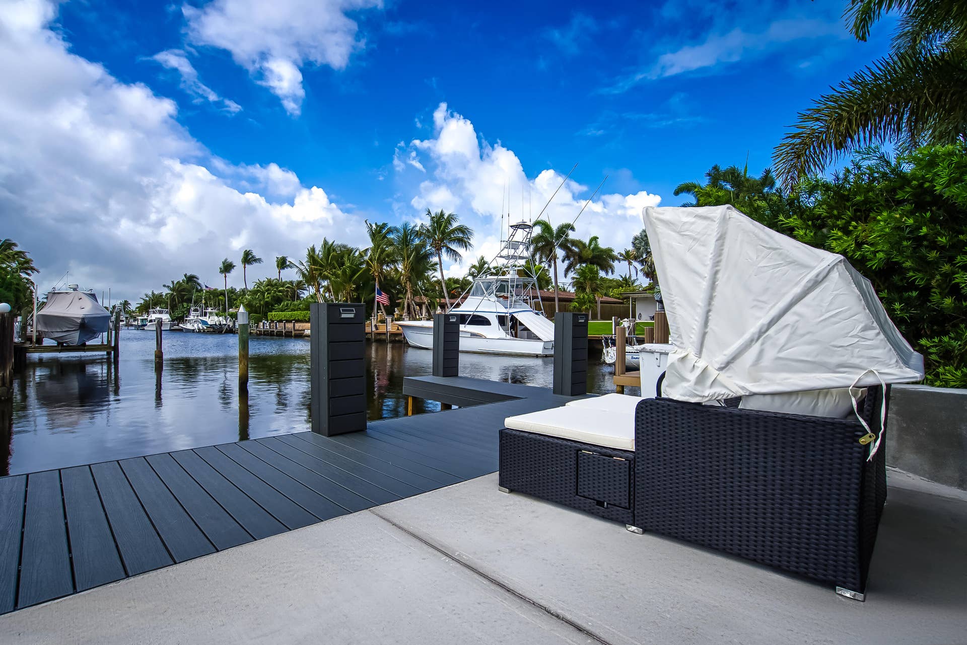 1250 SE 10TH Street, Deerfield Beach, Deerfield Beach, FL 33441 Waterfront property featuring a composite deck, concrete patio, deep water canal access, and mature palm trees