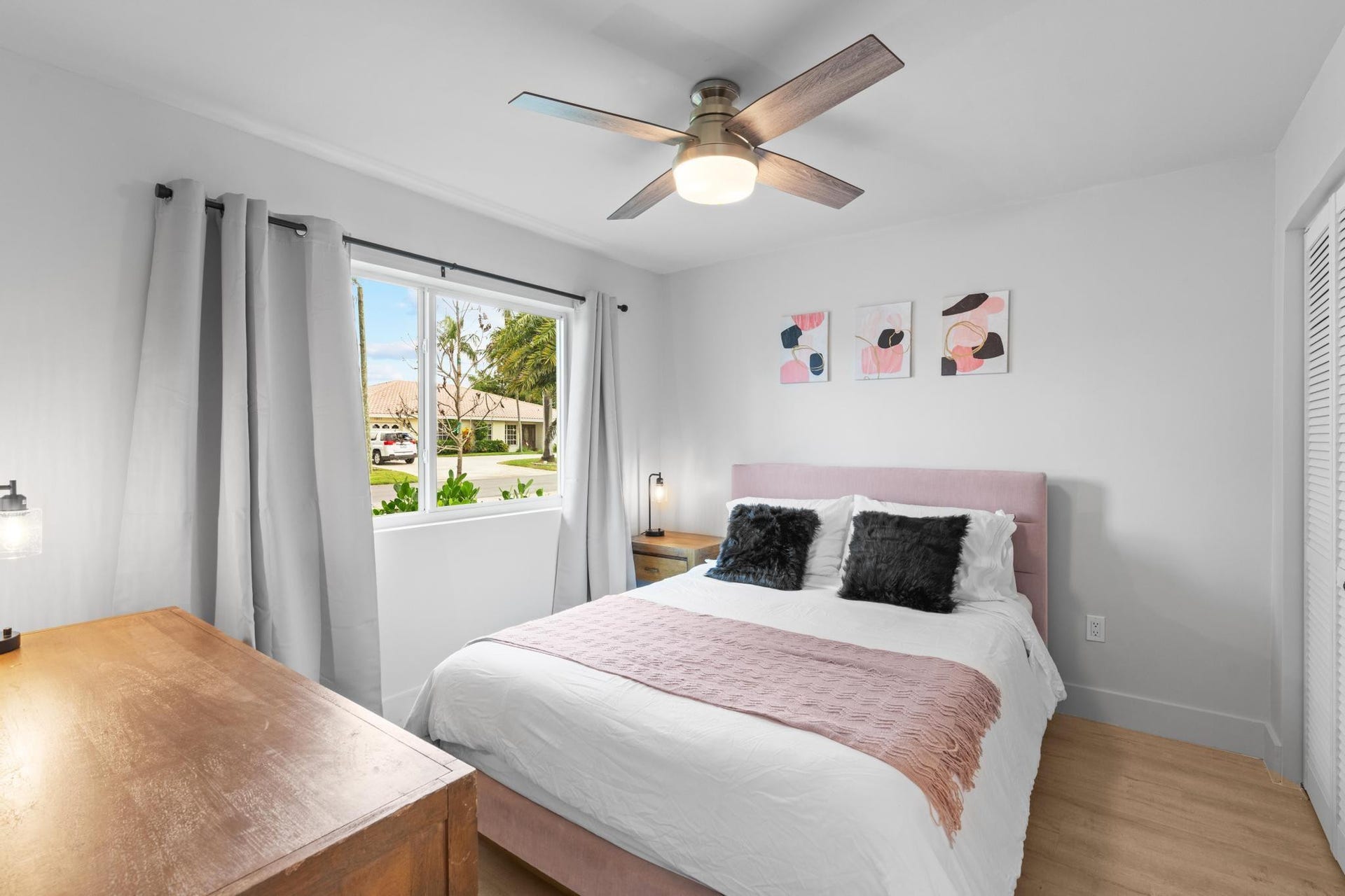 Wood-finish flooring, white walls, and a ceiling fan with integrated lighting
