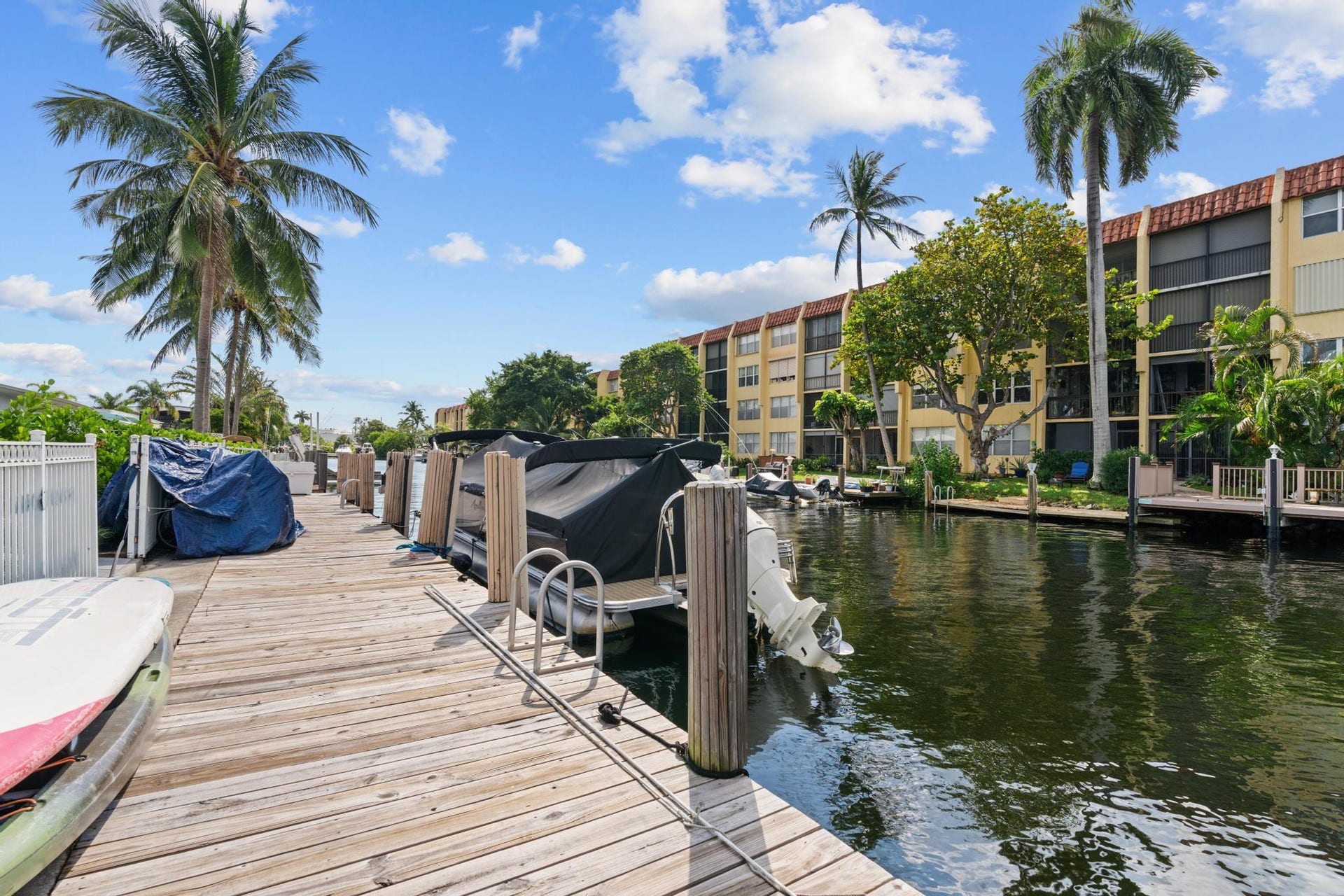 Waterside property with a private wooden dock, direct canal access, and tropical landscaping