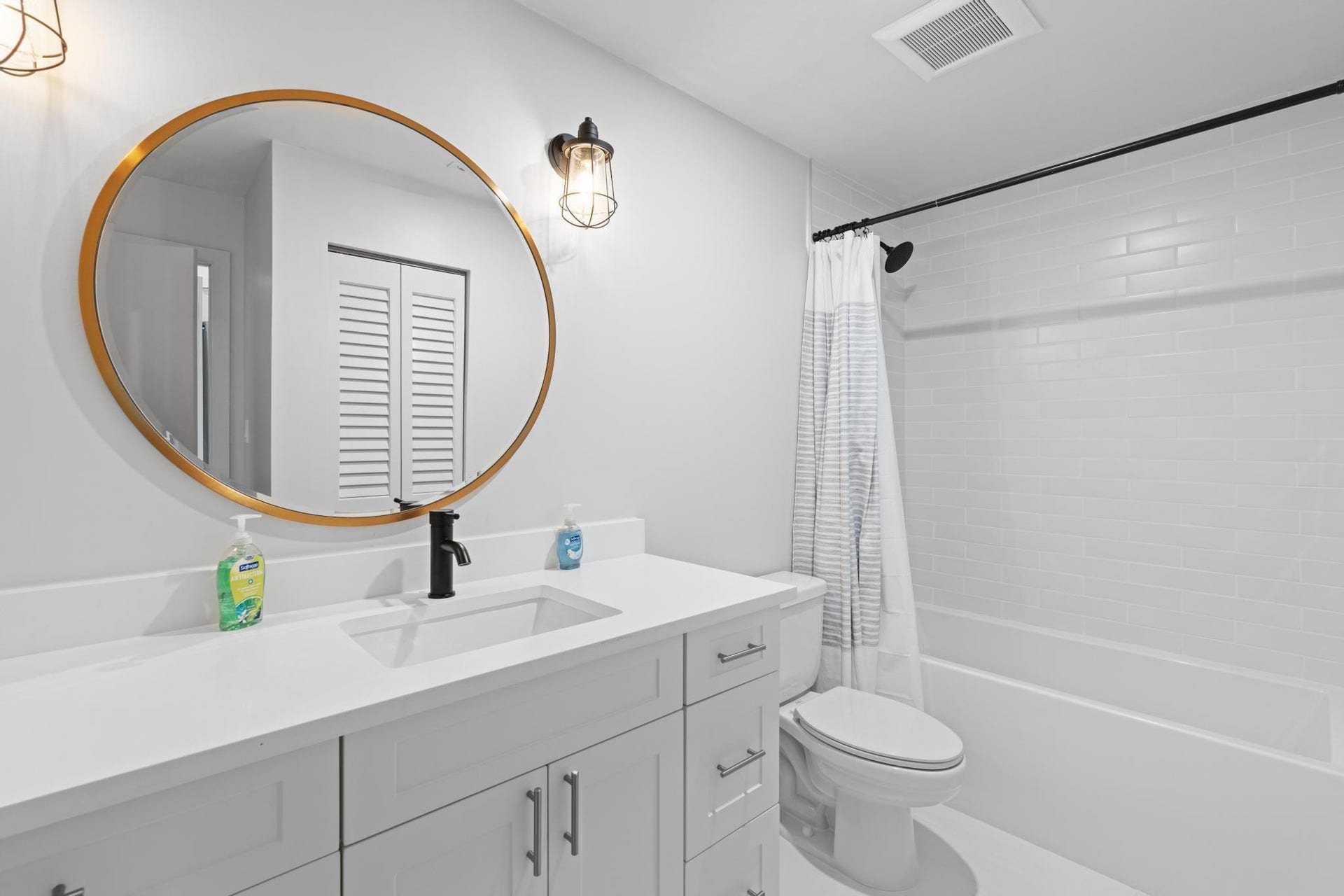 White subway tile shower surround with a matte black shower head and rod