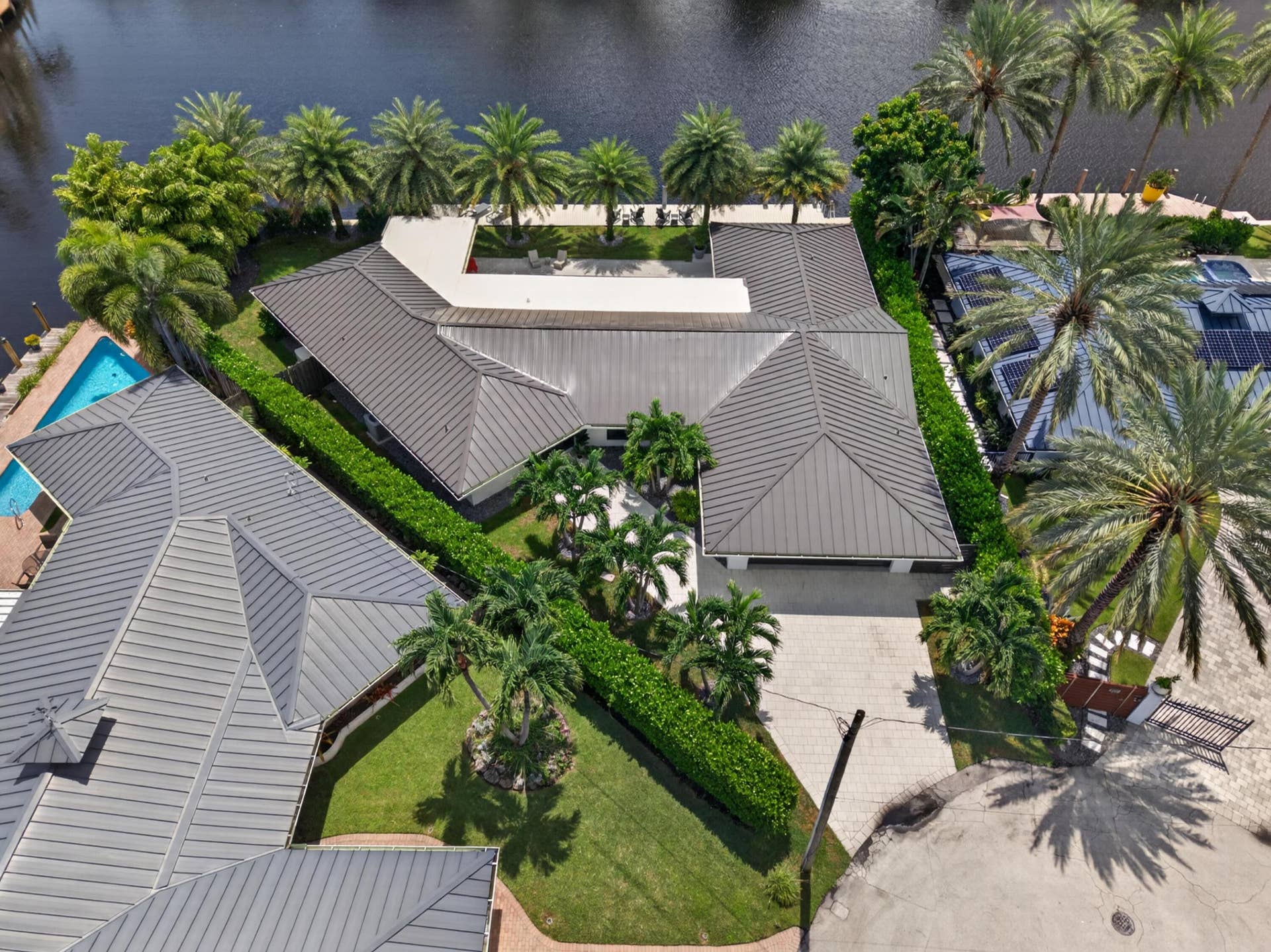 Aerial view if home with metal roof and tropical landscaping