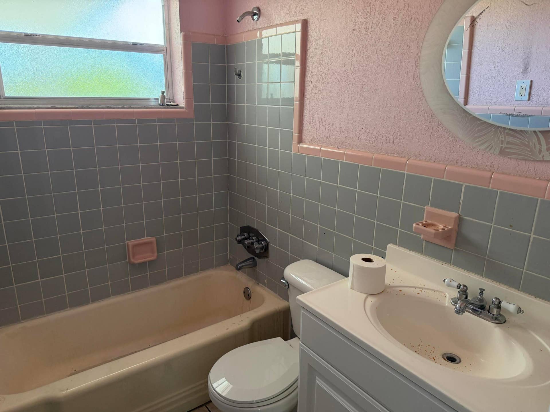 2924 NW 9TH Terrace, Wilton Manors, FL 33311 Hall Bathroom featuring a built-in tub, tiled shower surround, window with privacy glass, and a vanity with an integrated sink