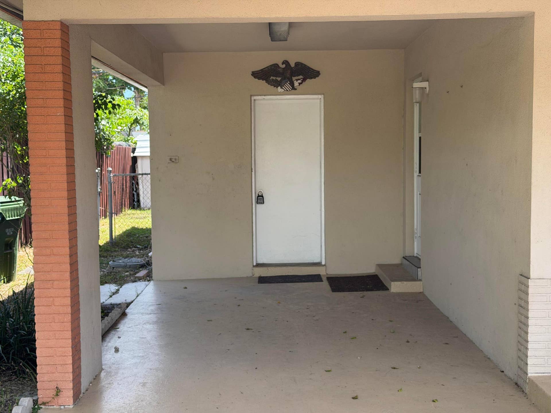 2924 NW 9TH Terrace, Wilton Manors, FL 33311 Covered entryway with painted concrete flooring, a brick column, and a white entry door