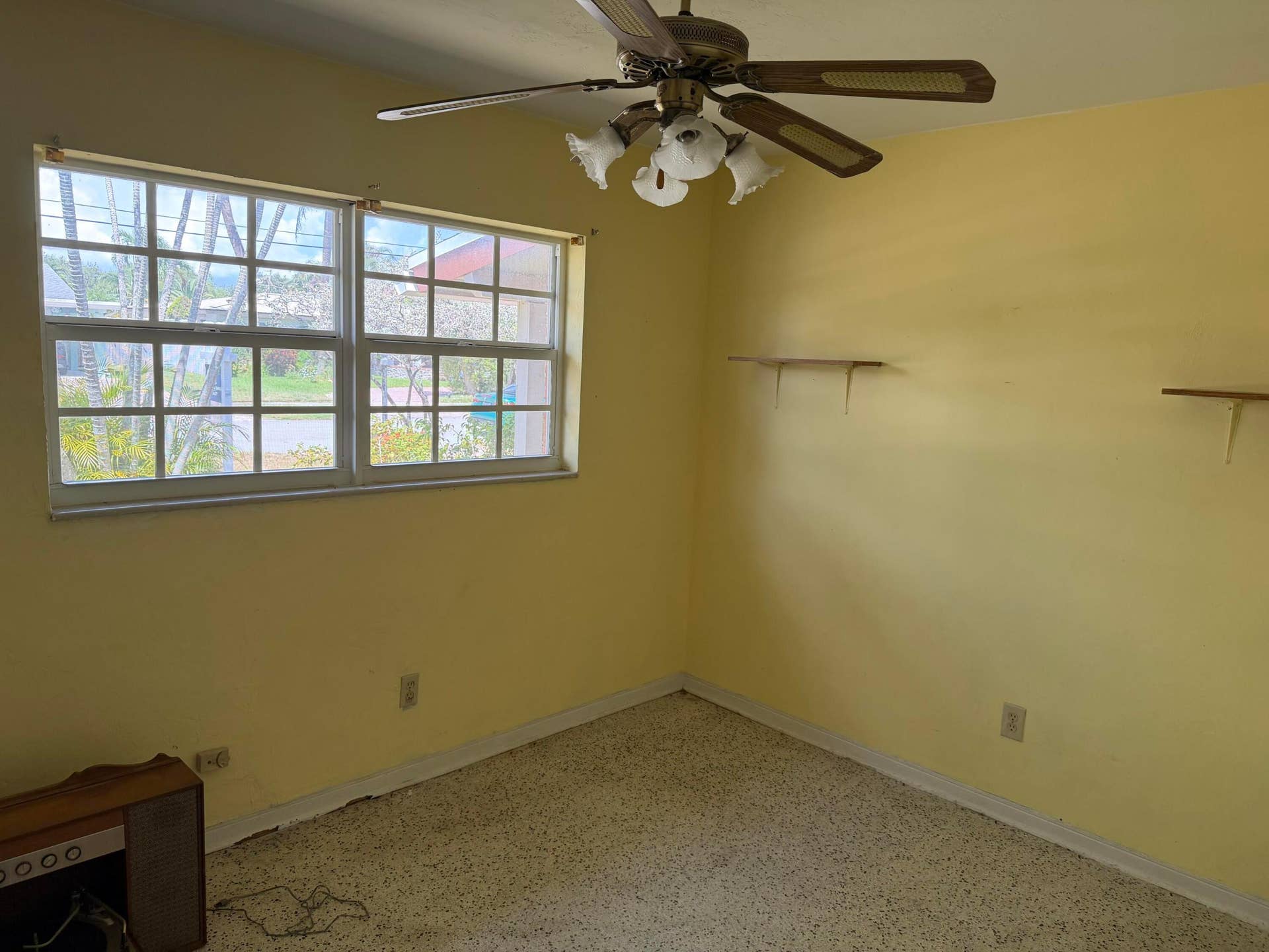2924 NW 9TH Terrace, Wilton Manors, FL 33311 3rd Bedroom. Dual pane window with grid detailing, ceiling fan with integrated lighting, and wall-mounted shelving