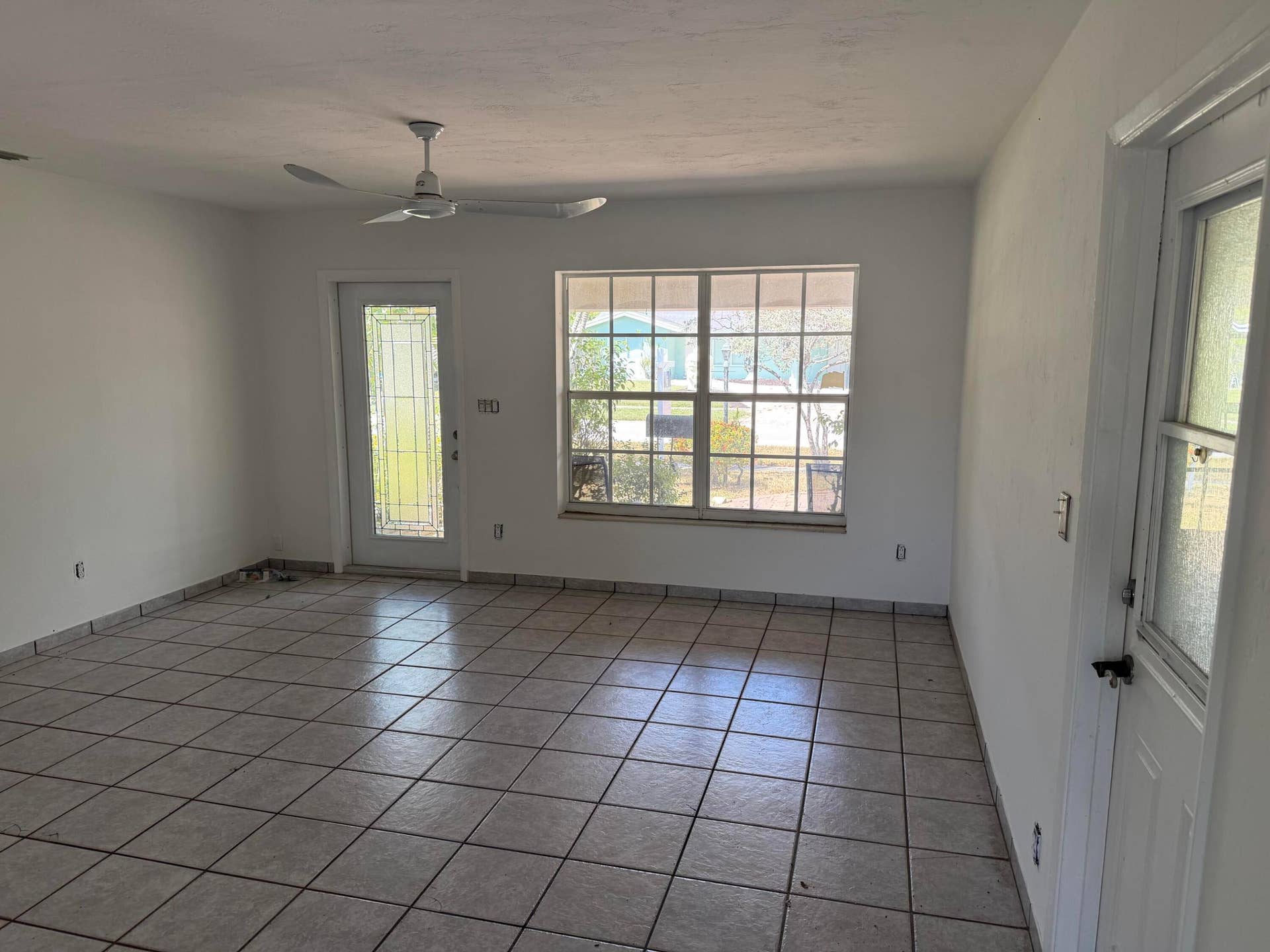 2924 NW 9TH Terrace, Wilton Manors, FL 33311 Ceramic tile flooring, white painted walls, ceiling fan, multiple windows for ample light, and a glass-paneled exterior door