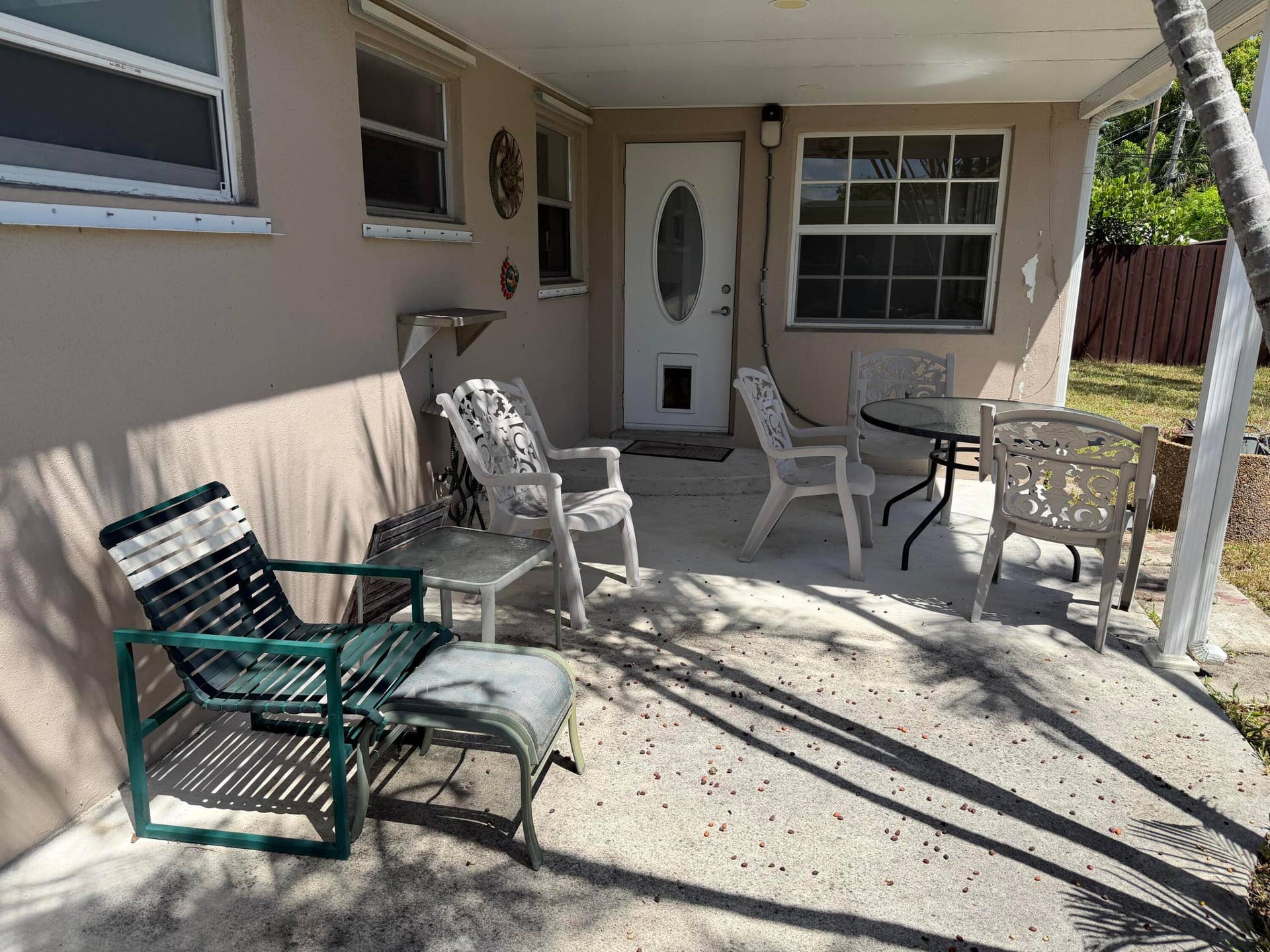 2924 NW 9TH Terrace, Wilton Manors, FL 33311 Covered patio with concrete flooring, accented by a white oval-paneled door and multiple windows
