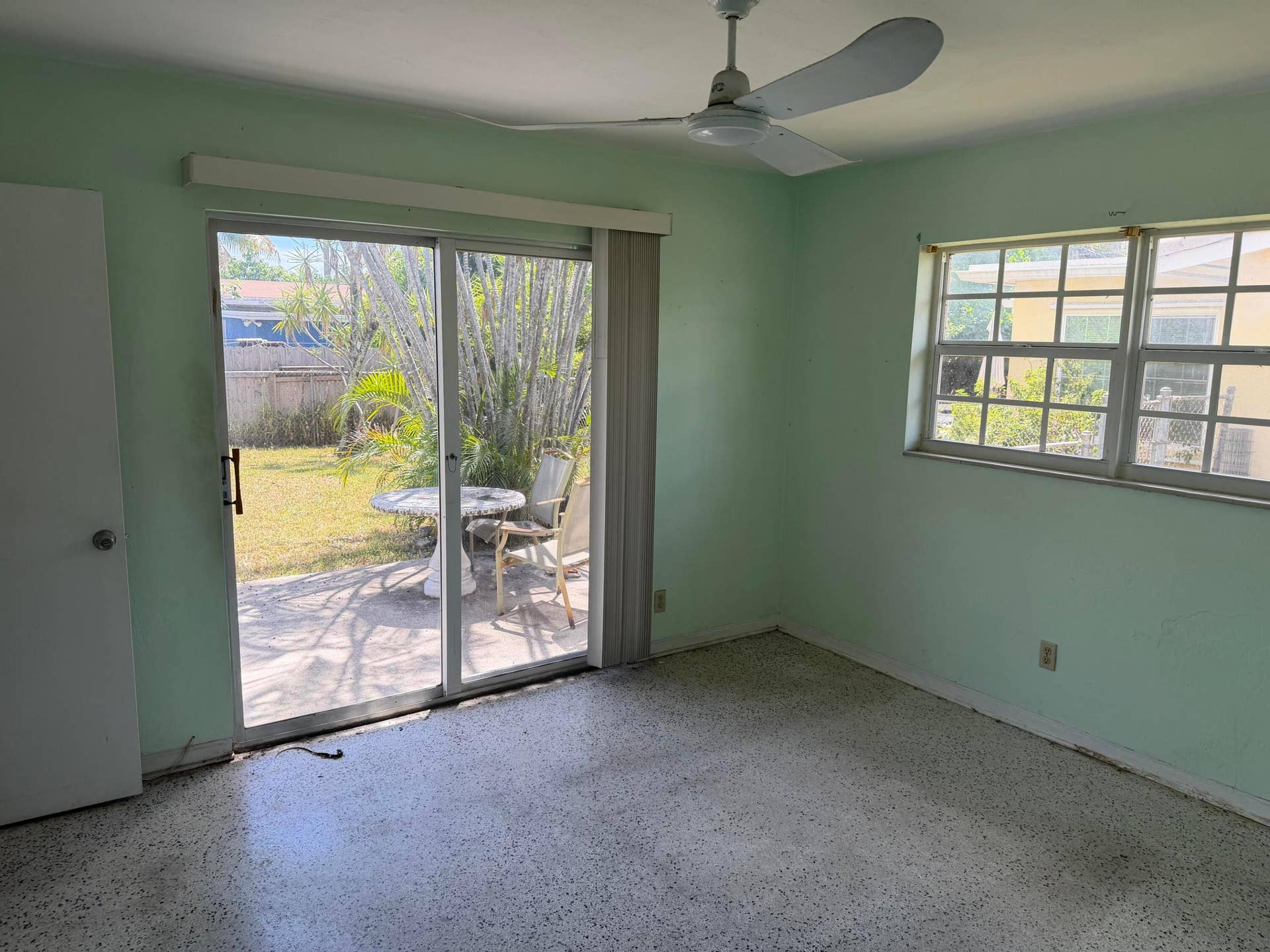 2924 NW 9TH Terrace, Wilton Manors, FL 33311 Primary Bedroom Sliding glass door access to a private patio, ceiling fan, and two multi-pane windows