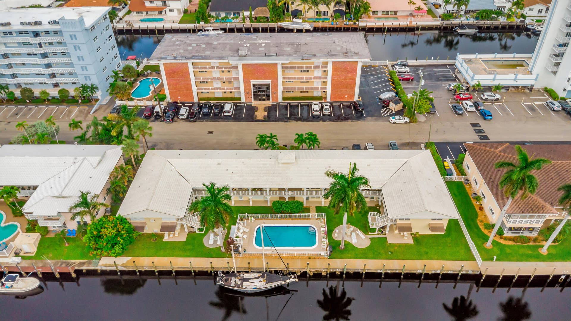 2840 NE 33RD Court, #2, Fort Lauderdale, FL 33306 Waterfront property featuring a private swimming pool, surrounding green space, and mature palm trees