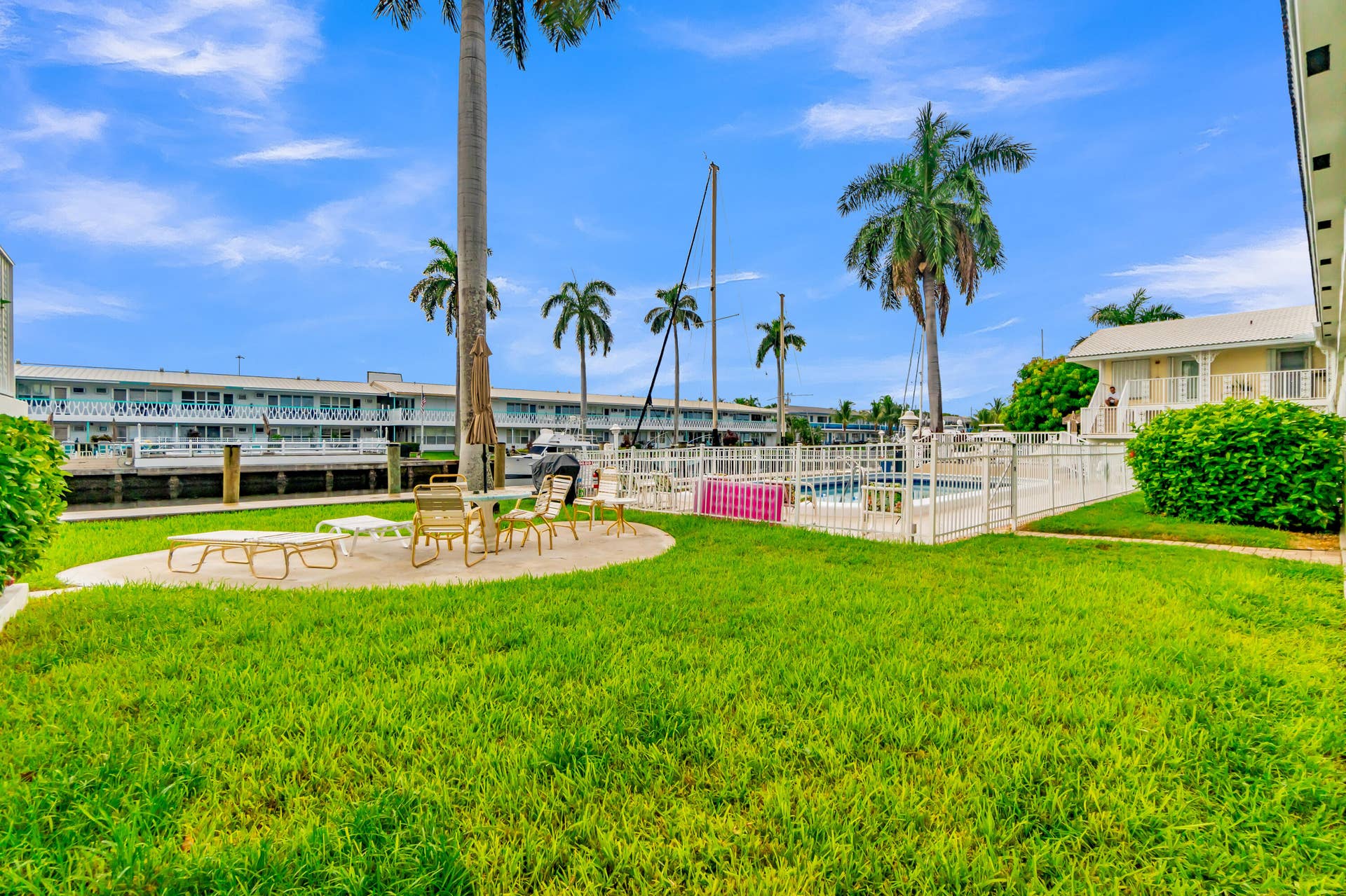 2840 NE 33RD Court, #2, Fort Lauderdale, FL 33306 Expansive grassy area with a concrete patio, adjacent to a fenced swimming pool