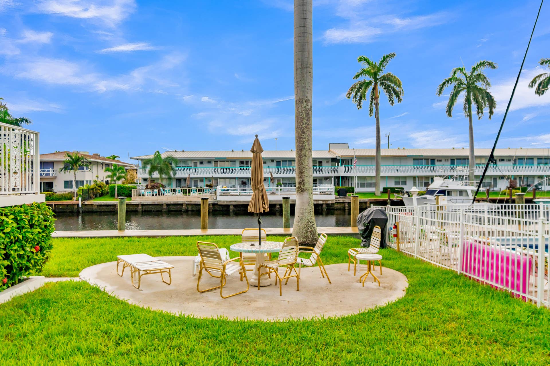 2840 NE 33RD Court, #2, Fort Lauderdale, FL 33306 Manicured lawn with a concrete patio, white metal fencing, and water frontage