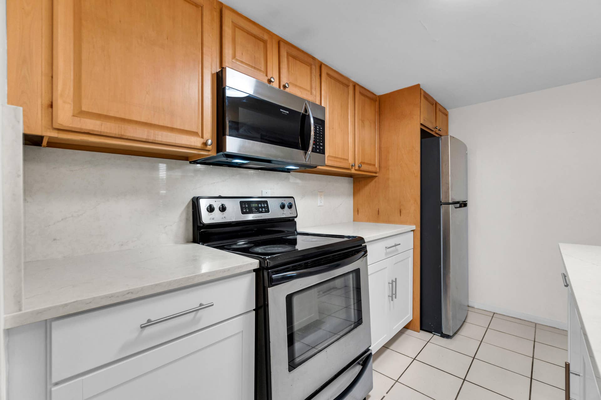 2840 NE 33RD Court, #2, Fort Lauderdale, FL 33306 Stainless steel appliances, light wood-finish cabinetry, white countertops, tile flooring, and a white backsplash