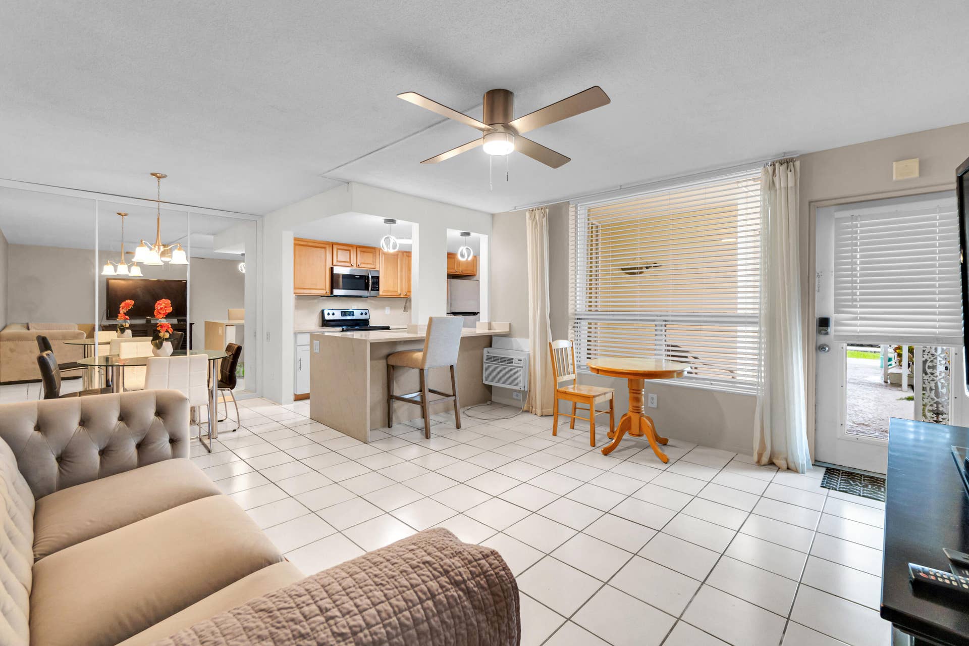 2840 NE 33RD Court, #2, Fort Lauderdale, FL 33306 Open concept living space featuring tile flooring, a ceiling fan, and a kitchen with wood cabinetry