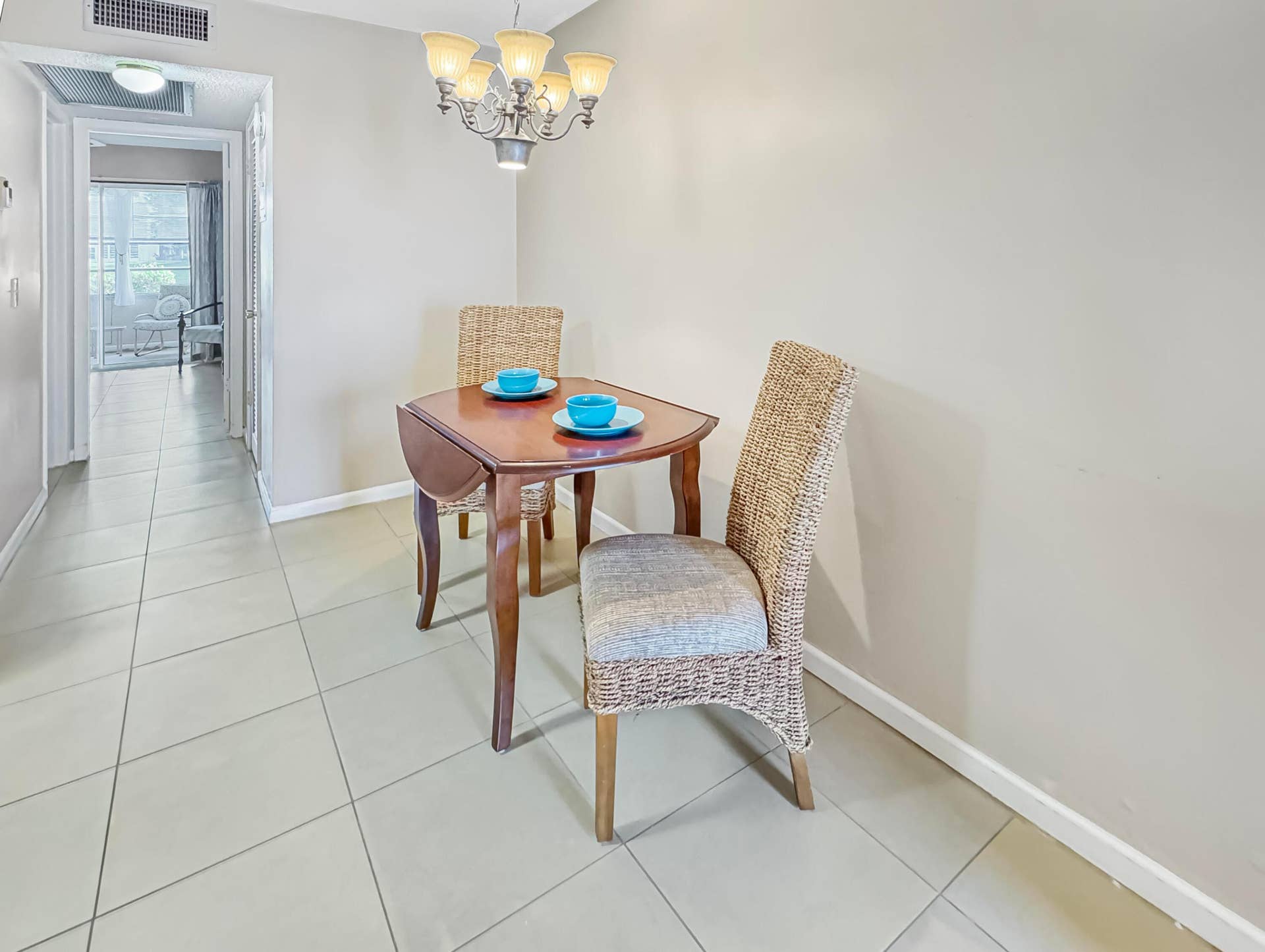 1013 HARWOOD C, #1013, Deerfield Beach, FL 33442 Ceiling-mounted chandelier fixture, neutral-toned wall paint, ceramic tile flooring, and white trim molding