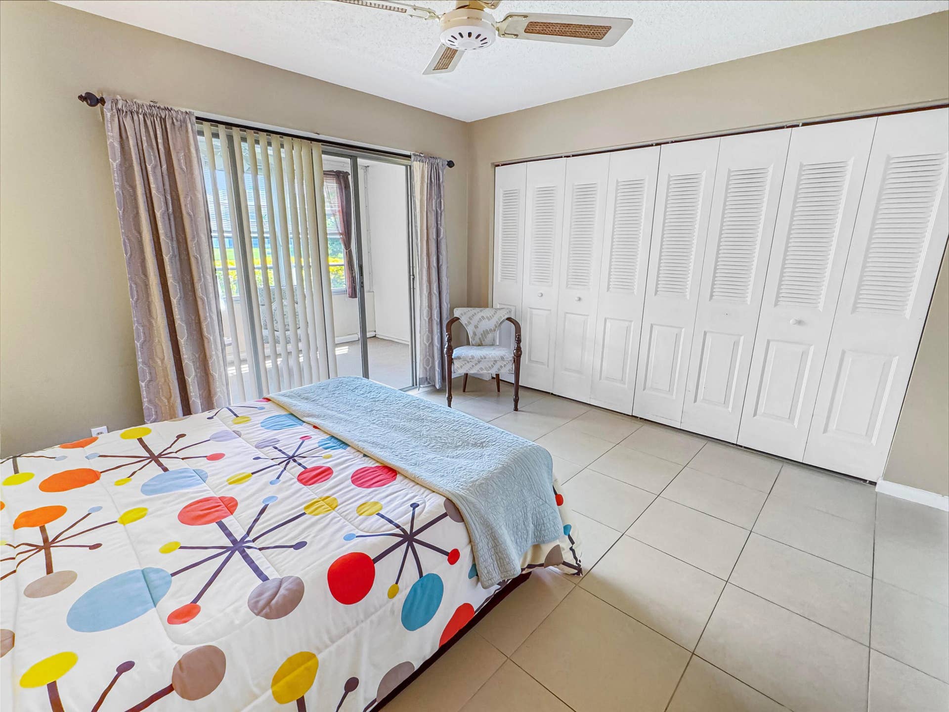 1013 HARWOOD C, #1013, Deerfield Beach, FL 33442 Tile flooring, sliding glass door, overhead ceiling fan, and louvered bi-fold closet doors
