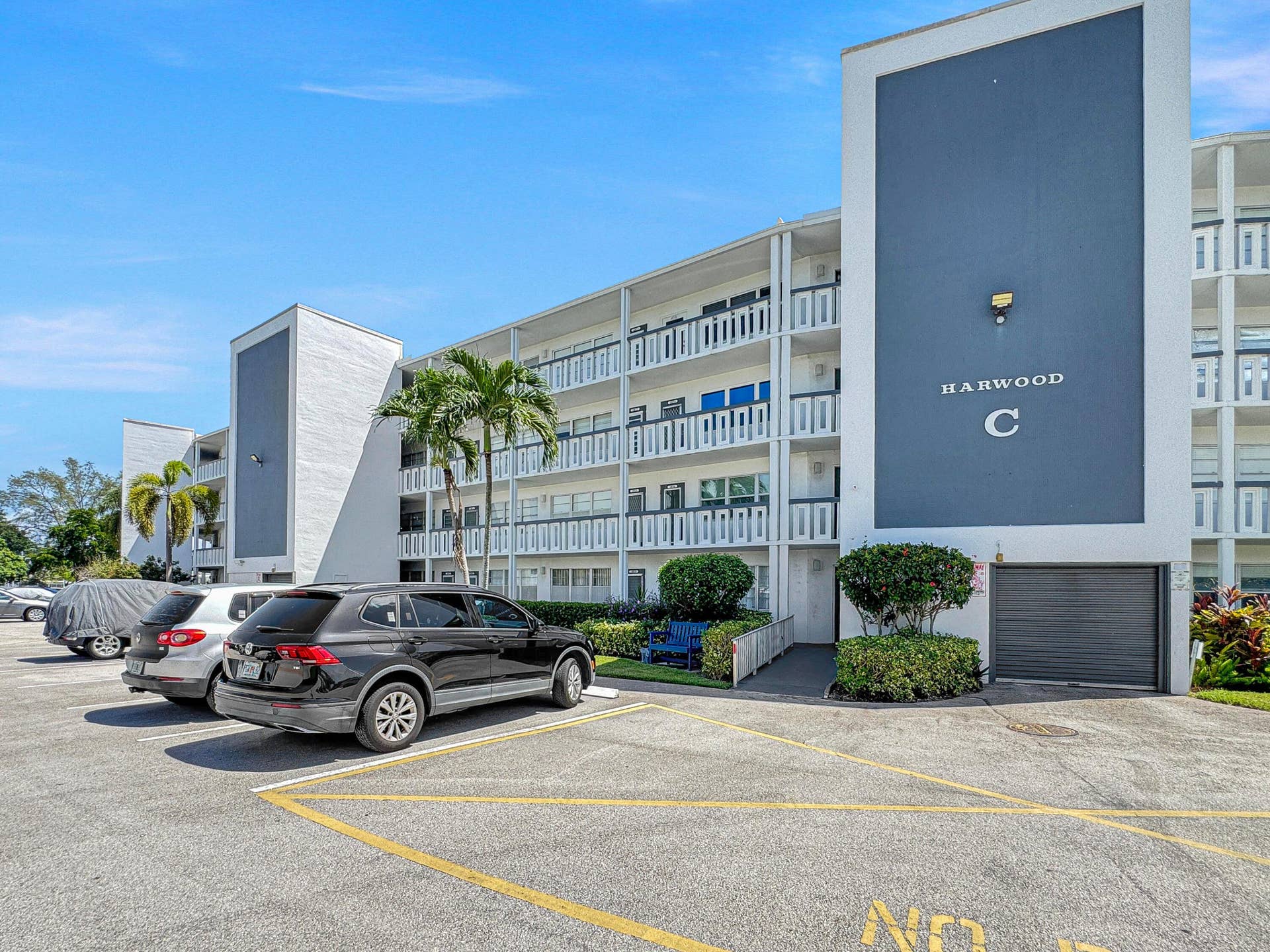 1013 HARWOOD C, #1013, Deerfield Beach, FL 33442 Concrete residential building with multiple balconies, a covered entry, and dedicated parking