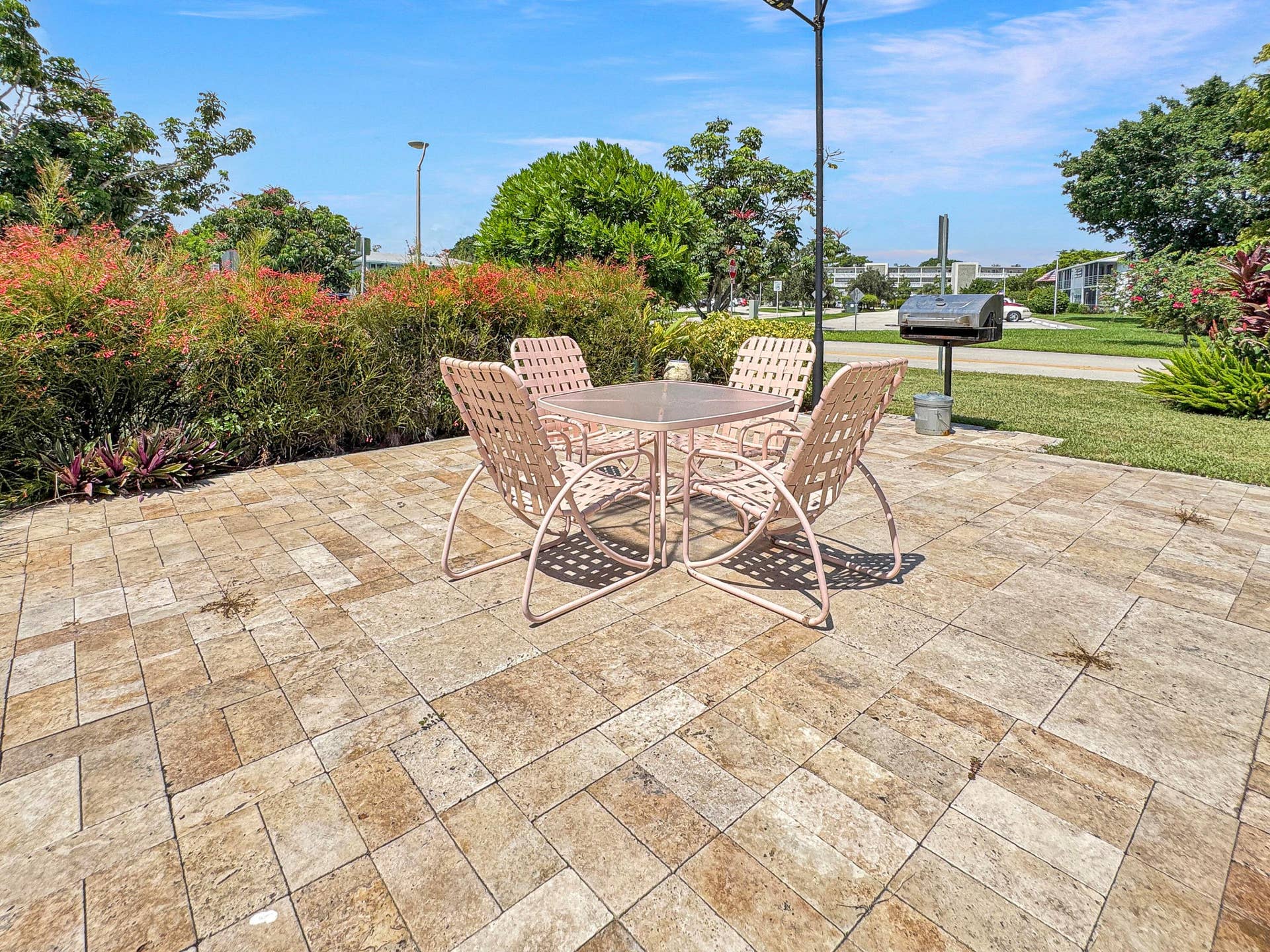 1013 HARWOOD C, #1013, Deerfield Beach, FL 33442 Expansive paver patio with a built-in barbecue grill and surrounding mature landscaping