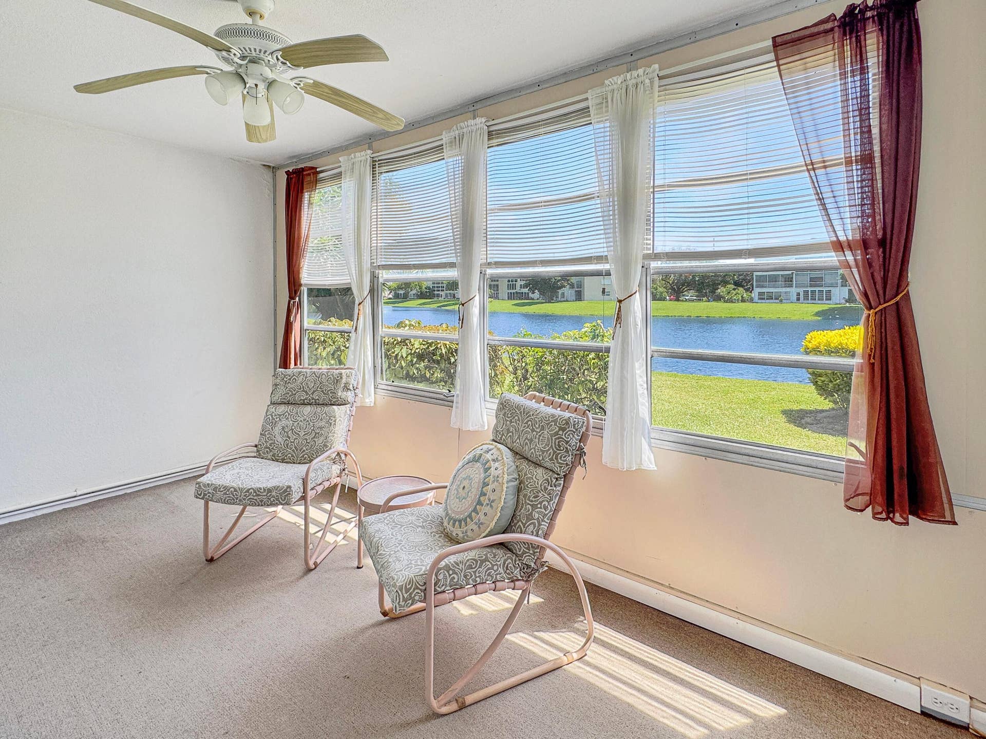 1013 HARWOOD C, #1013, Deerfield Beach, FL 33442 Expansive windows showcasing water frontage, ceiling fan with integrated lighting, and neutral wall tones